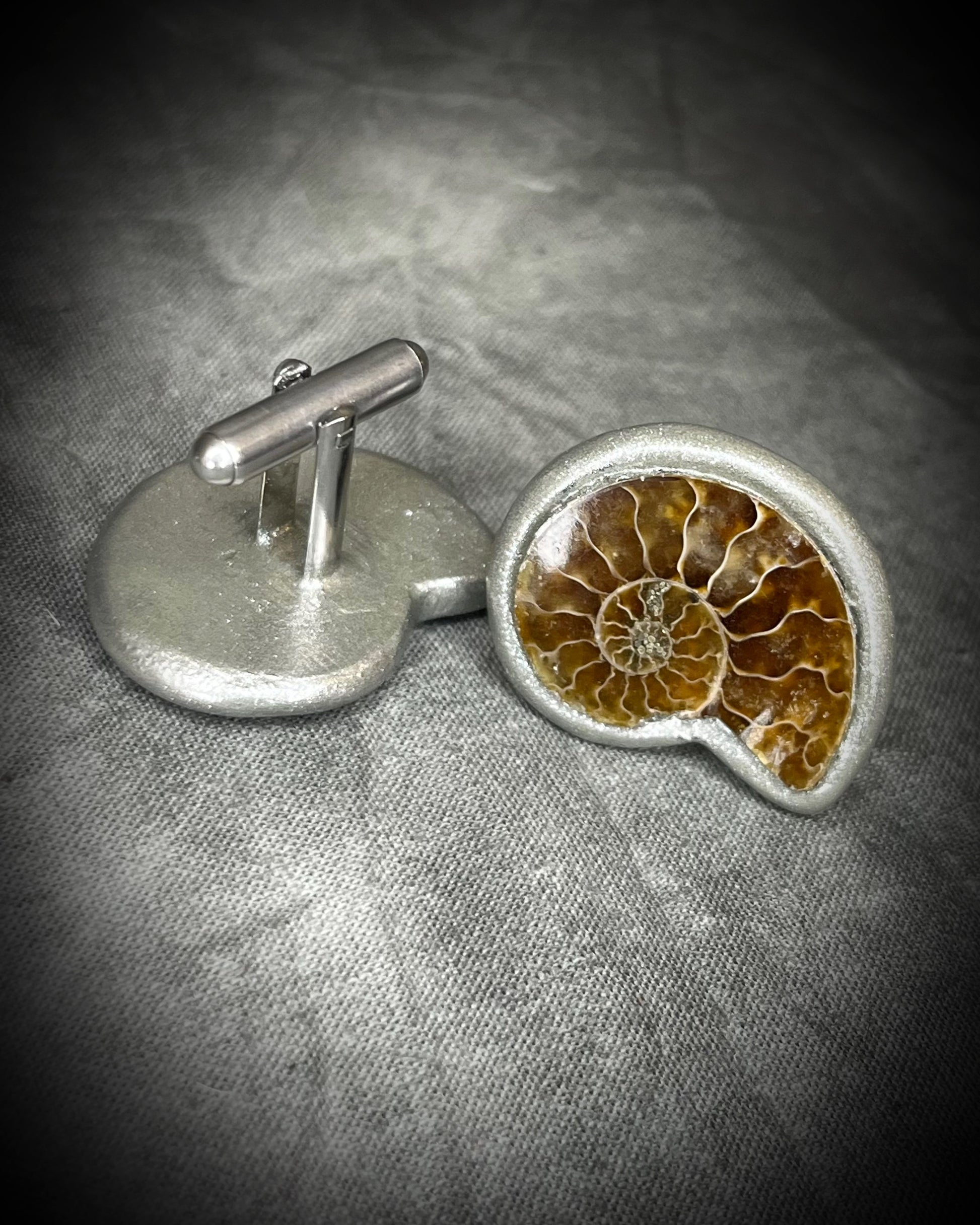 Genuine ammonite fossil cufflinks with silver finish and stainless steel cufflink bases, featuring natural spiral fossils. One-of-a-kind mens accessories by Become Spellbound.