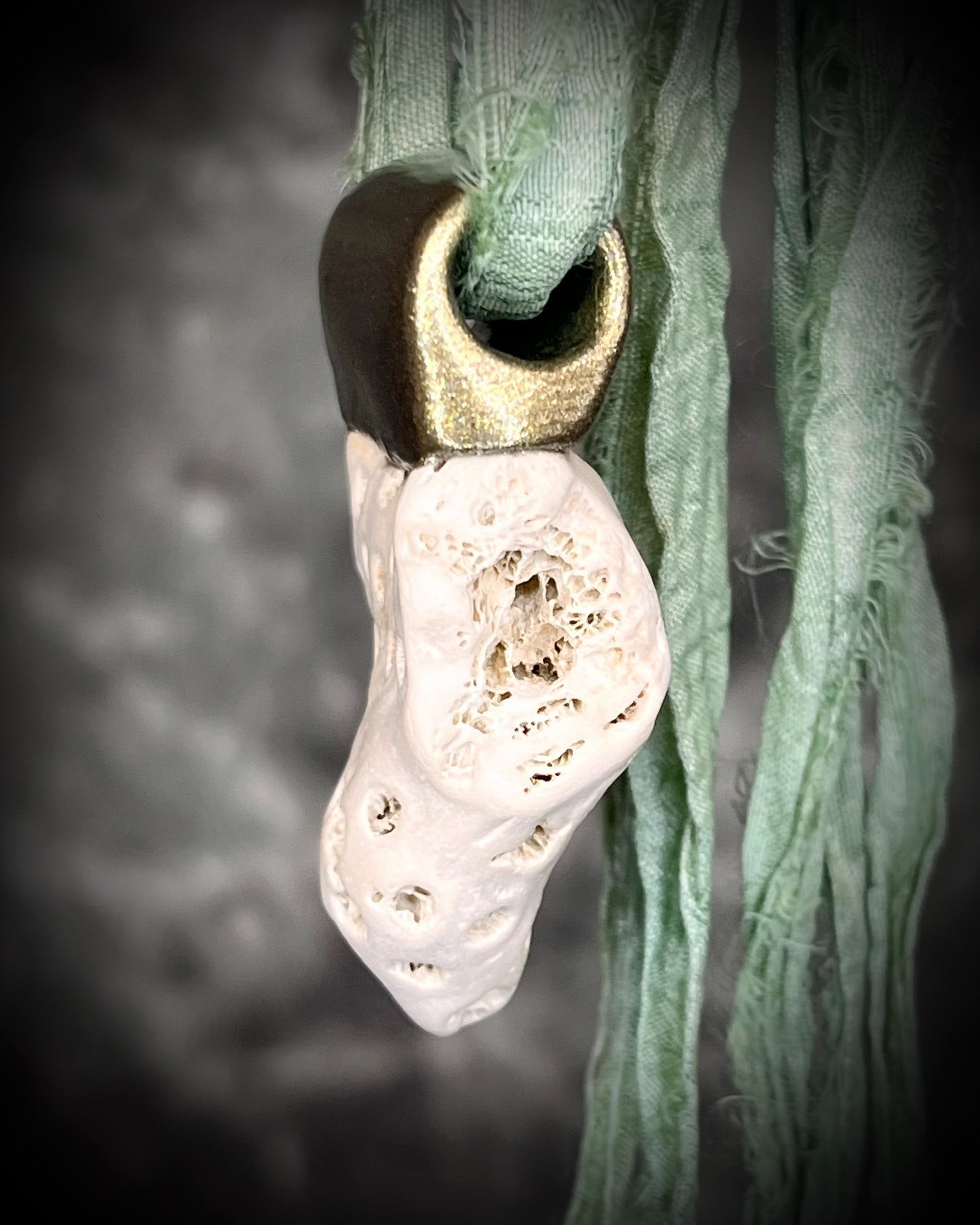 Genuine fossil coral set in a gold setting and hung from sea green recycled silks as a beachy oceanic summer jewelry look. Necklace handmade in Baltimore with coral from Calvert Cliffs.