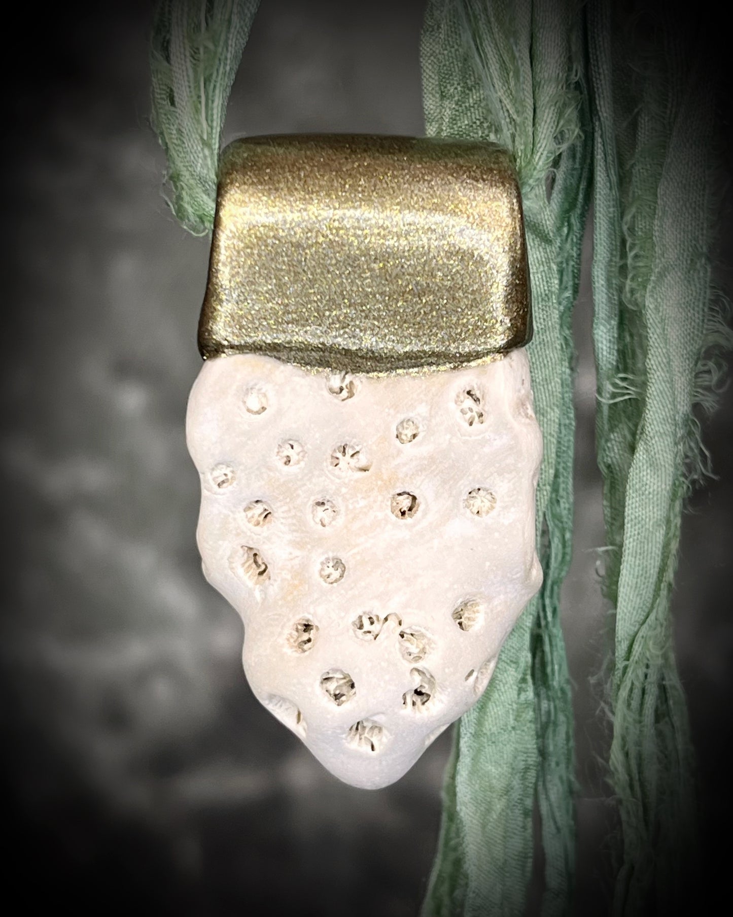 Genuine fossil coral set in a gold setting and hung from sea green recycled silks as a beachy oceanic summer jewelry look. Necklace handmade in Baltimore with coral from Calvert Cliffs.
