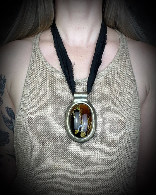 Glowing XXL Statement Necklace featuring a large Indonesian Amber gemstone with a gold setting, hung from black recycled silk. Maximalist holiday gift for her!