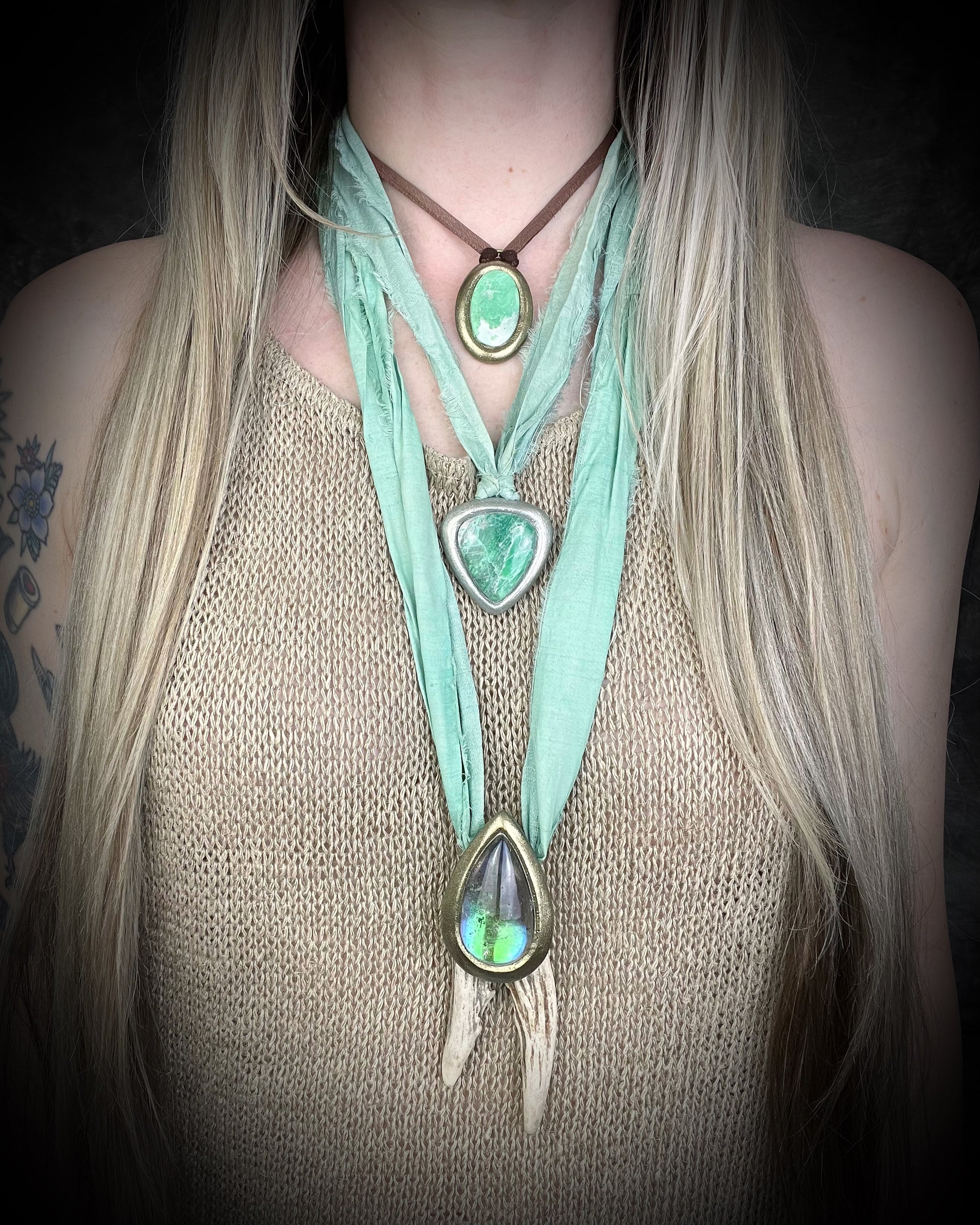 Goddess layering Necklaces with green crystal quartz teardrop pendants and variscite gemstones hung from mint green recycled silk and earthy brown leather on a person wearing a beige top. Spiritual jewelry gift for her. 