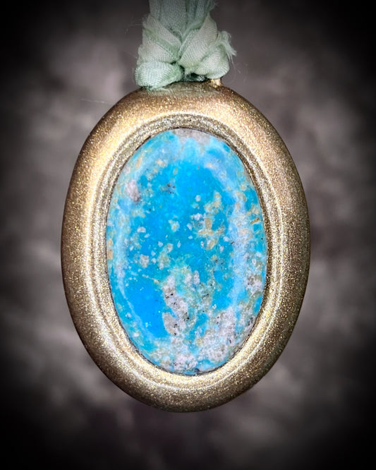 Gold-framed turquoise handmade pendant with vibrant blue green stone hung from sea green recycled silks. Oceanic treasure necklace for her. 
