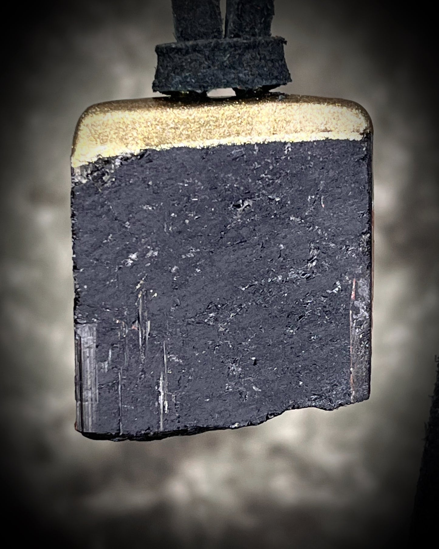 Gold finish, square shaped raw stone Black tourmaline grounding and protection pendant hung from black leather for an earthy adornment. Open back to touch skin and ground you. 