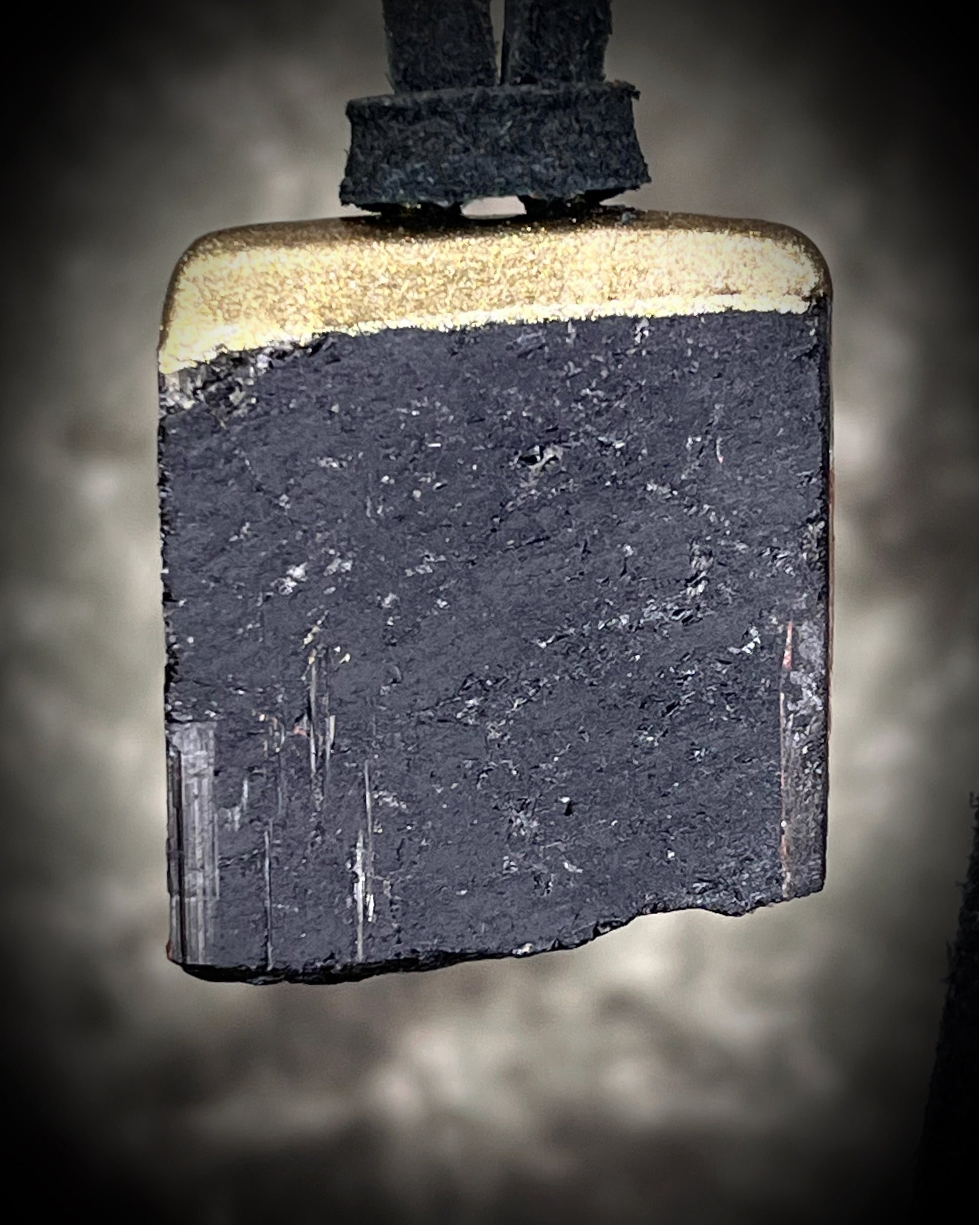 Gold finish, square shaped raw stone Black tourmaline grounding and protection pendant hung from black leather for an earthy adornment. Open back to touch skin and ground you. 