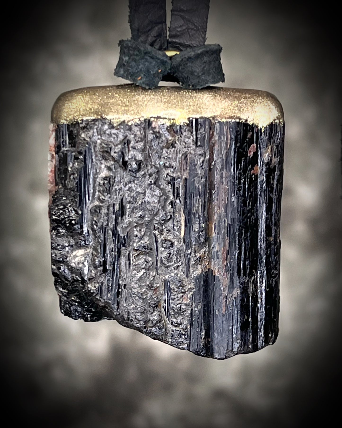 Gold finish, square shaped raw stone Black tourmaline grounding and protection pendant hung from black leather for an earthy adornment. Open back to touch skin and ground you. 