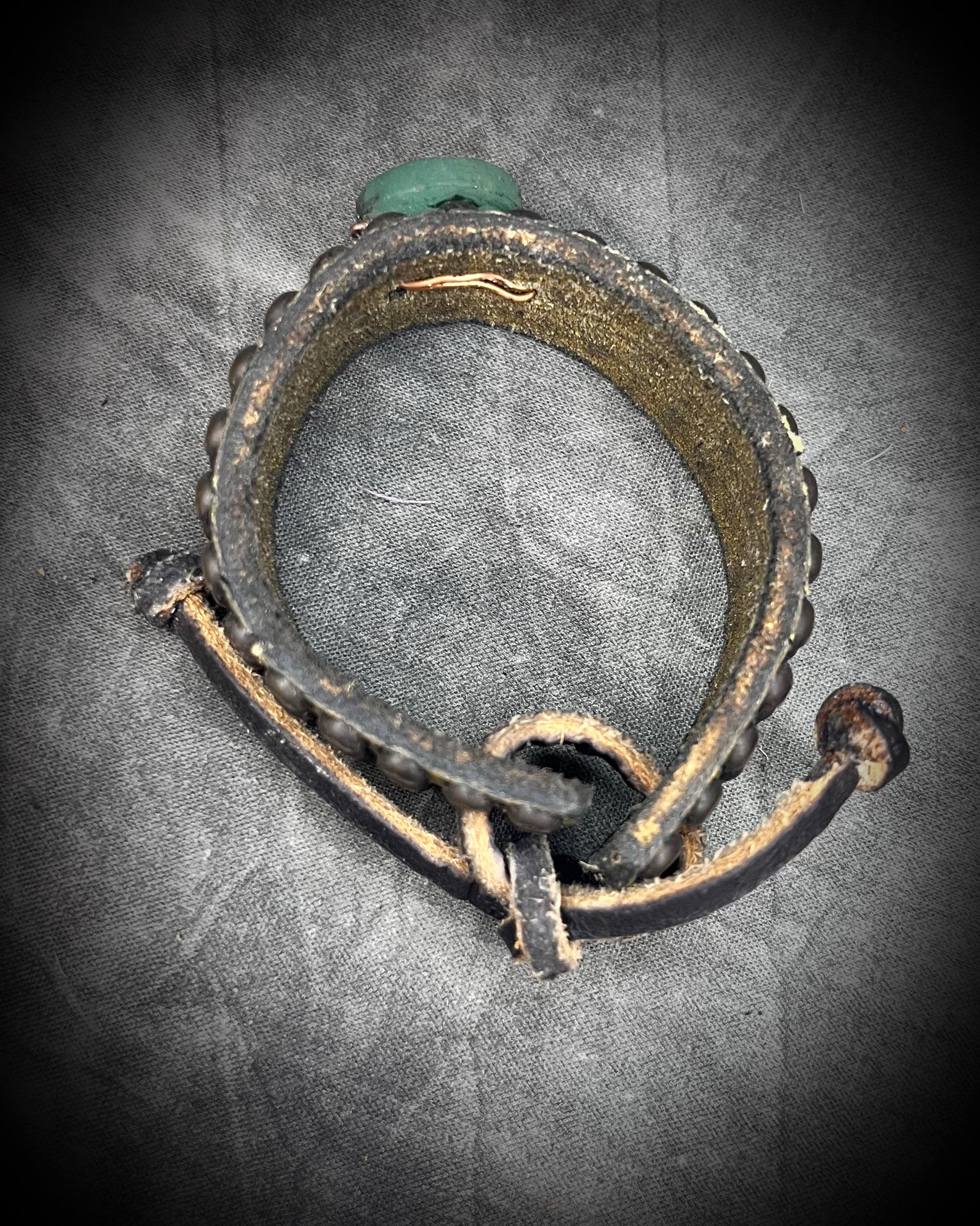 Golden brown studded leather cuff bracelet featuring a circular Green Aventurine focal stone. Rugged leatherwork with a lucky, calming stone, gift for him or her.