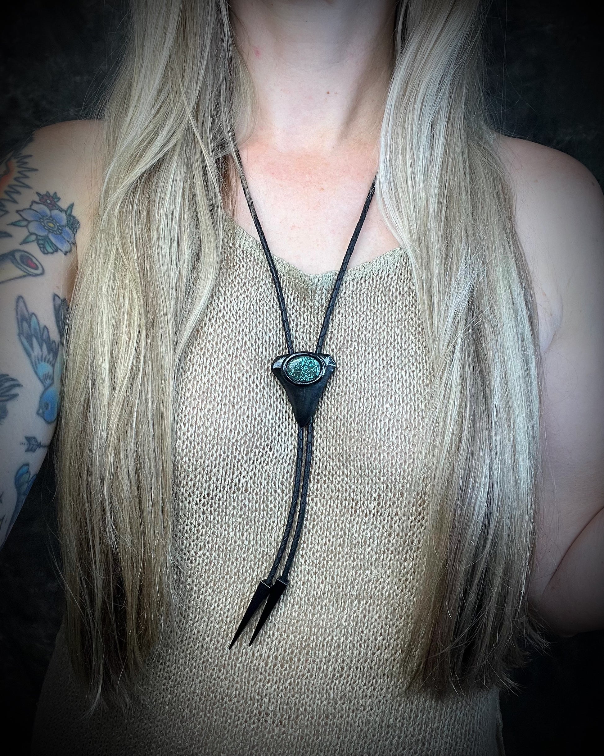 Great White shark tooth fossil bolo tie with black and turquoise-colored turquoise, black leather, black finish, and black spike tips.