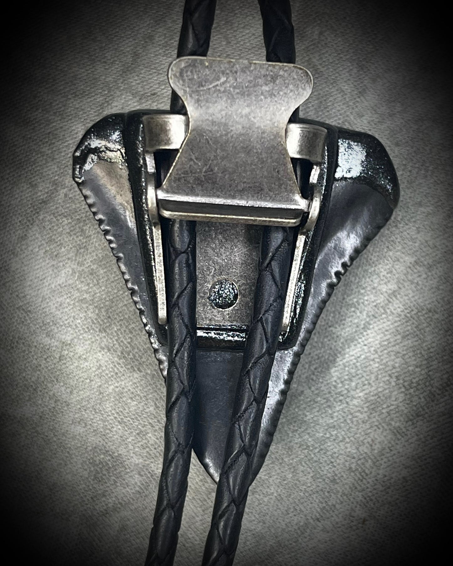 Great White shark tooth fossil bolo tie with black and turquoise-colored turquoise, black leather, black finish, and black spike tips.