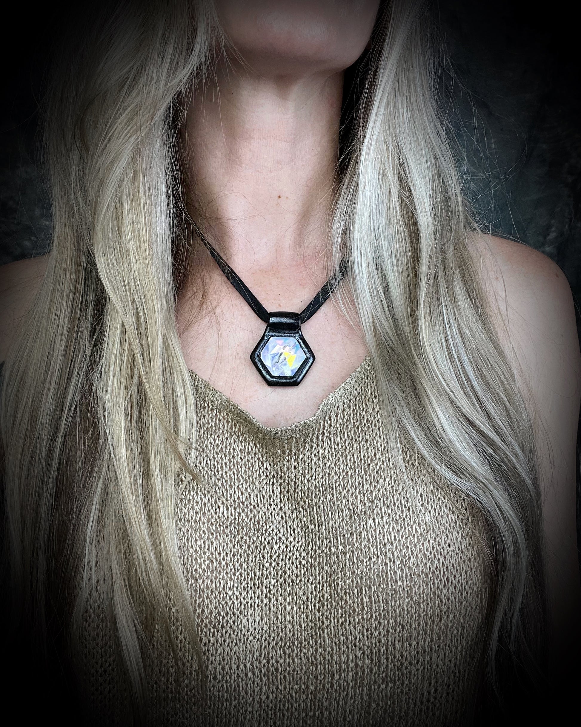 Handcrafted opalescent quartz crystal talisman with iridescent shimmer, black framed pendant on leather cord, mystical statement necklace for seekers and dreamers.