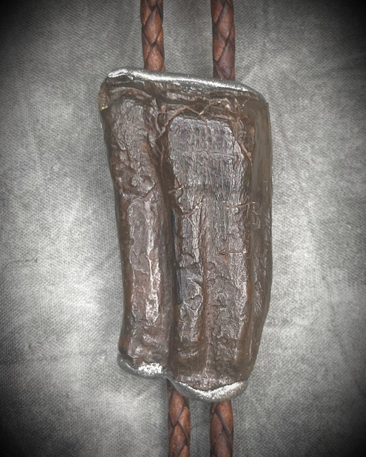 Handmade Equus bolo tie featuring horse tooth fossil centerpiece with gunmetal silver sculptural detailing, brass findings, spike tip ends, and leather cord bolo necklace. Natural history talisman for him, handmade in Baltimore Maryland. 