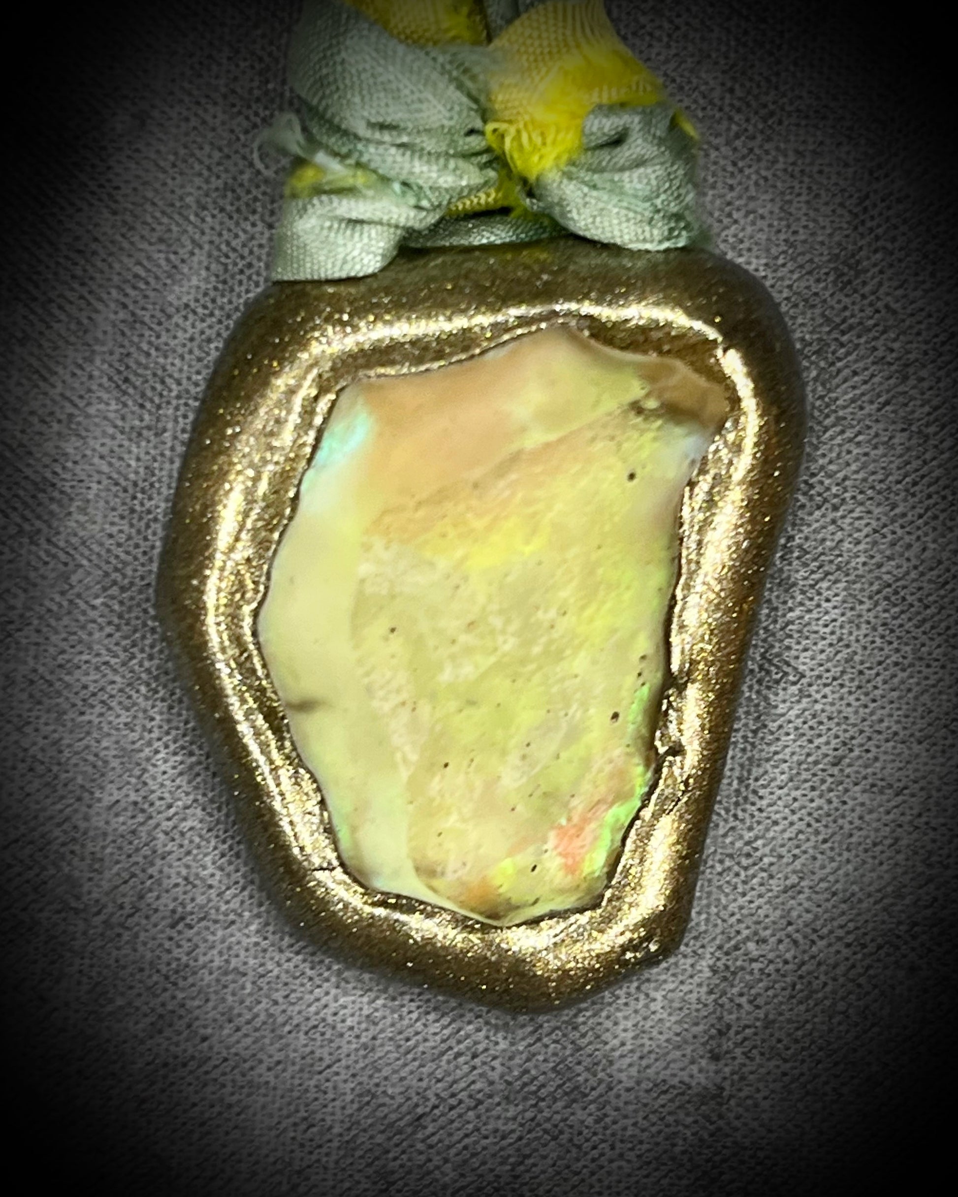 Handmade Libyan Desert Glass necklaces with luminous shifting flashes of green, gold, peach, and rose on sea green and yellow recycled silk by Become Spellbound.