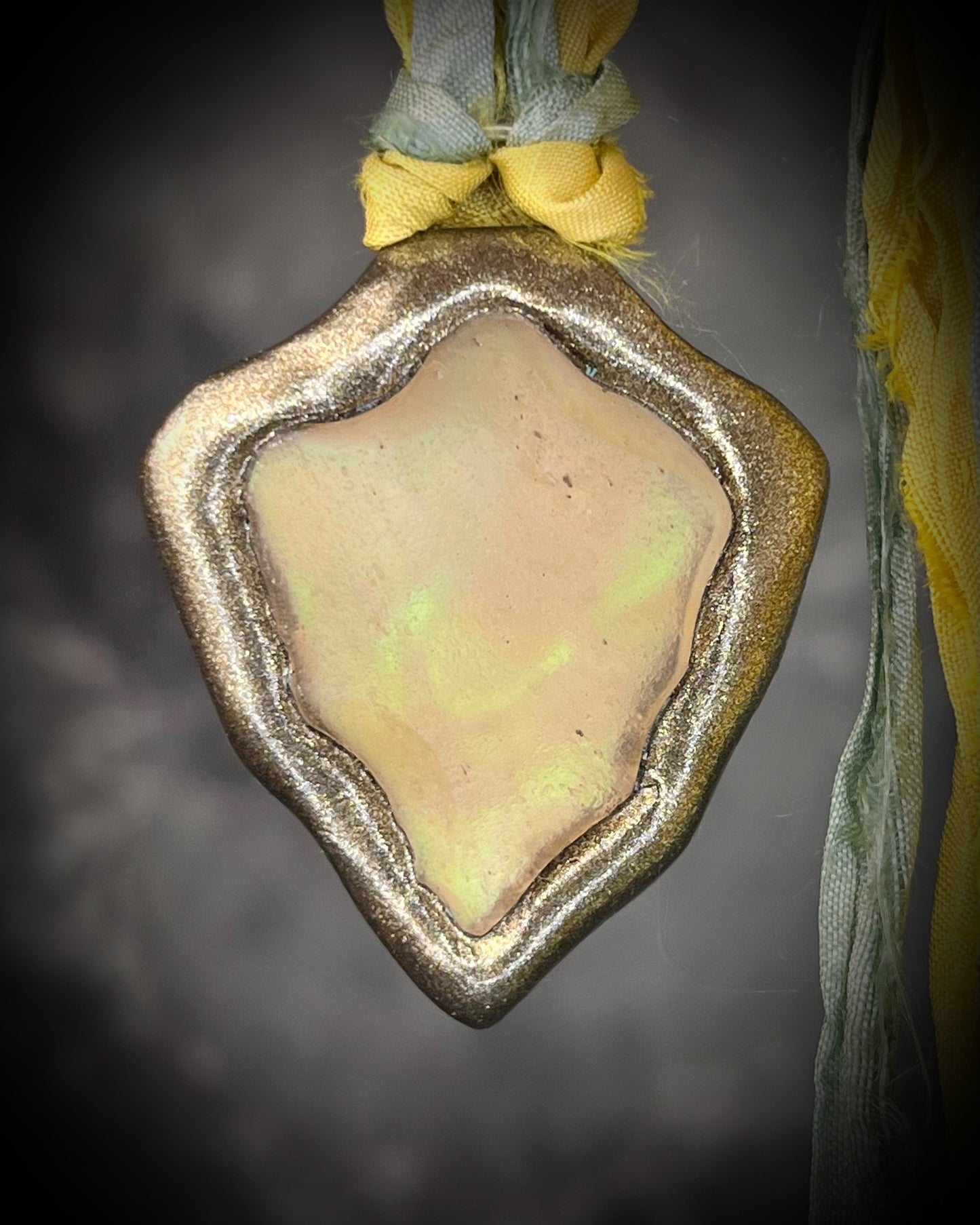 Handmade Libyan Desert Glass necklaces with luminous shifting flashes of green, gold, peach, and rose on sea green and yellow recycled silk by Become Spellbound.