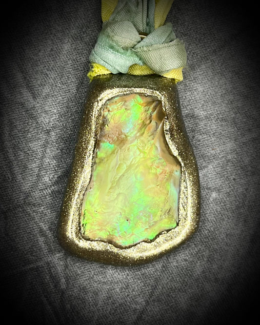 Handmade Libyan Desert Glass necklaces with luminous shifting flashes of green, gold, peach, and rose on sea green and yellow recycled silk by Become Spellbound.