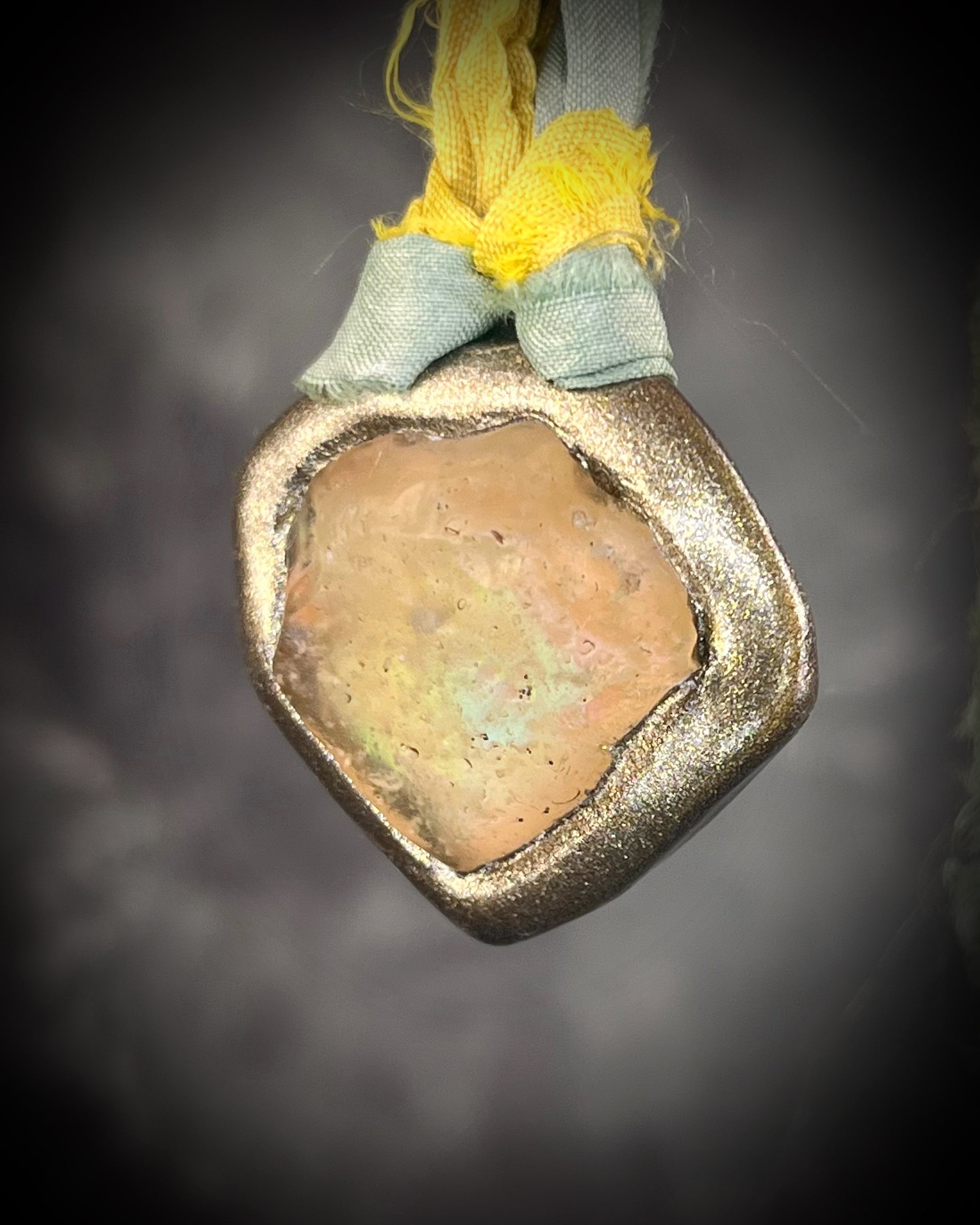 Handmade Libyan Desert Glass pendant necklaces with luminous shifting flashes of green, gold, peach, and rose on sea green and yellow recycled silk by Become Spellbound.