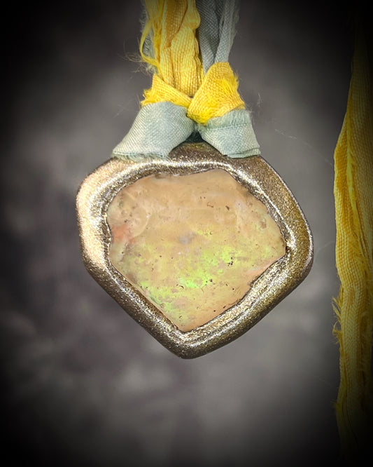 Handmade Libyan Desert Glass pendant necklaces with luminous shifting flashes of green, gold, peach, and rose on sea green and yellow recycled silk by Become Spellbound.