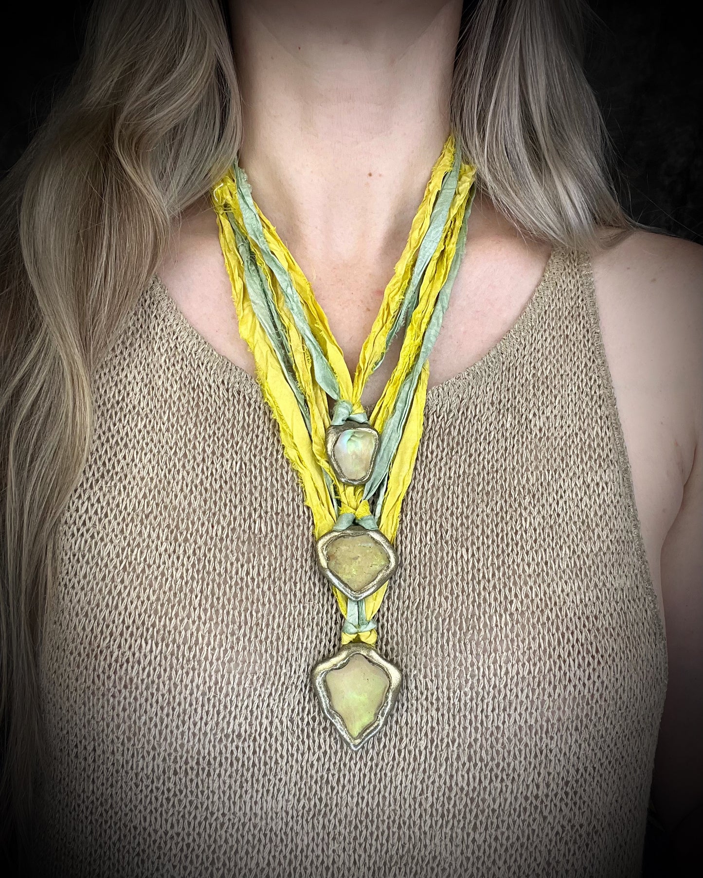 Handmade Libyan Desert Glass pendant necklaces with luminous shifting flashes of green, gold, peach, and rose on sea green and yellow recycled silk by Become Spellbound.