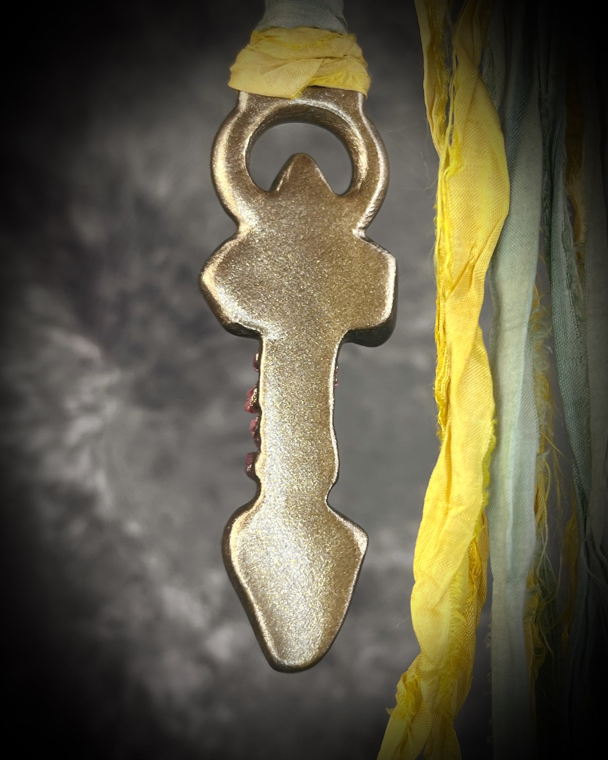 Handmade Libyan Desert Glass talisman necklace with raw ruby crystals, lepidolite, green tourmaline, and recycled silk ties featuring luminous shifting flashes of color.
