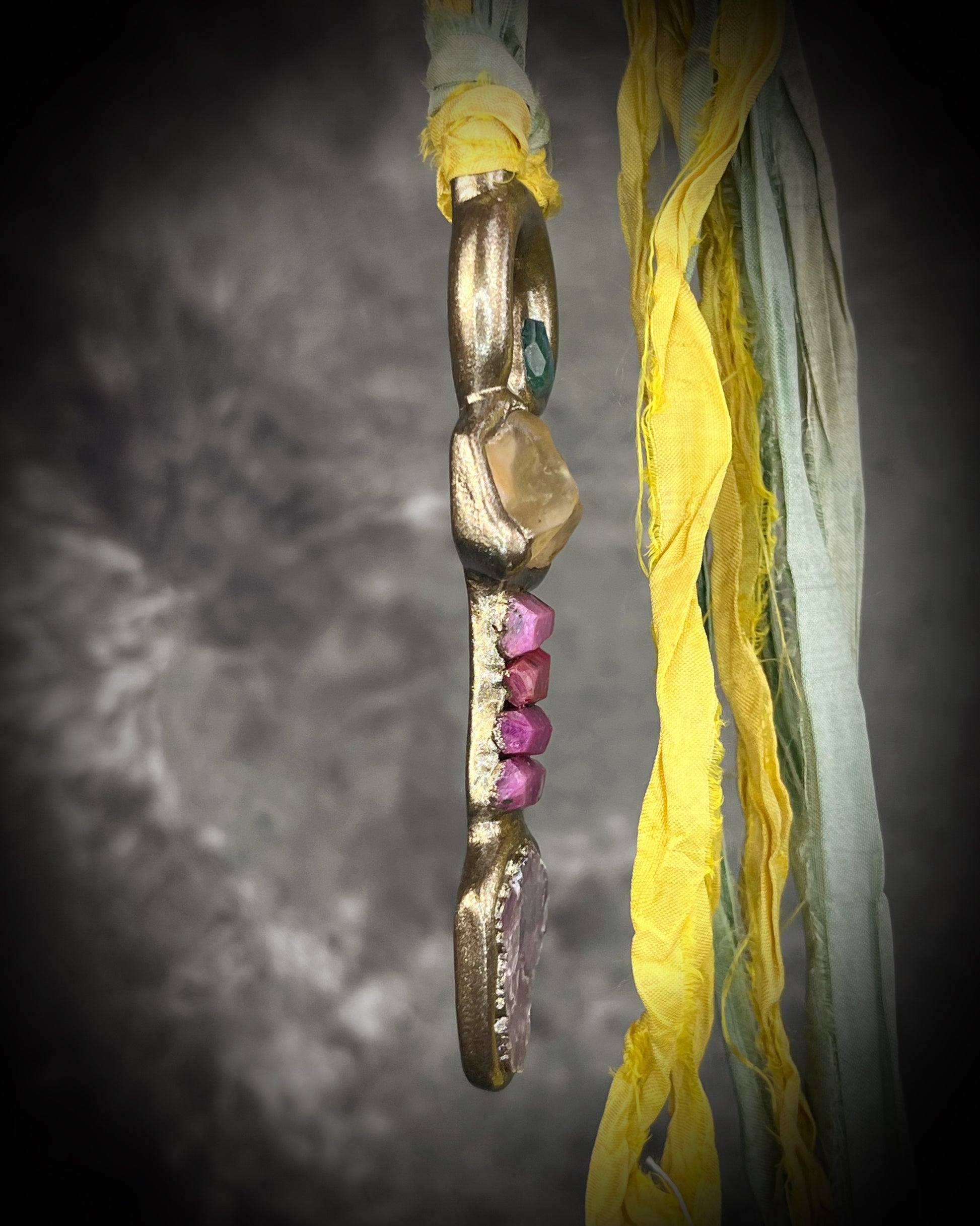 Handmade Libyan Desert Glass talisman necklace with raw ruby crystals, lepidolite, green tourmaline, and recycled silk ties featuring luminous shifting flashes of color.