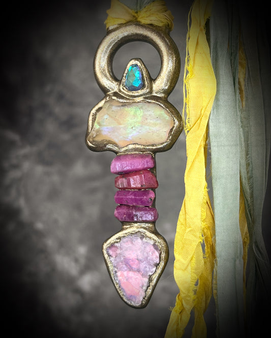 Handmade Libyan Desert Glass talisman necklace with raw ruby crystals, lepidolite, green tourmaline, and recycled silk ties featuring luminous shifting flashes of color.