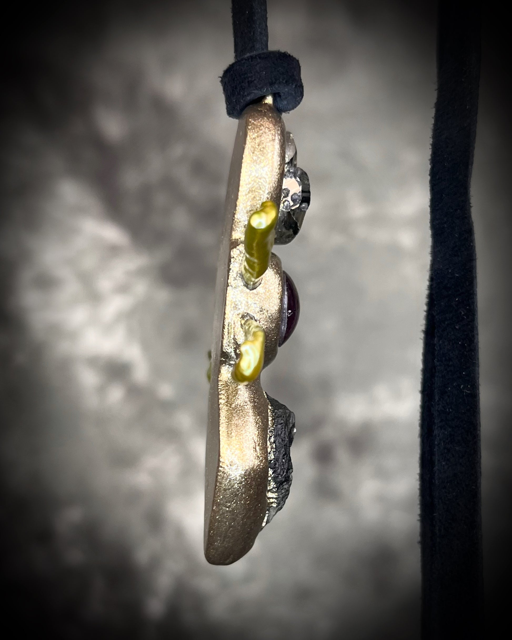 Handmade Moldavite Power Talisman Necklace with Pyrite, Garnet and Green Pearls. Transformation pendant hung from soft black leather. Unisex spiritual elevation talisman. Side view.