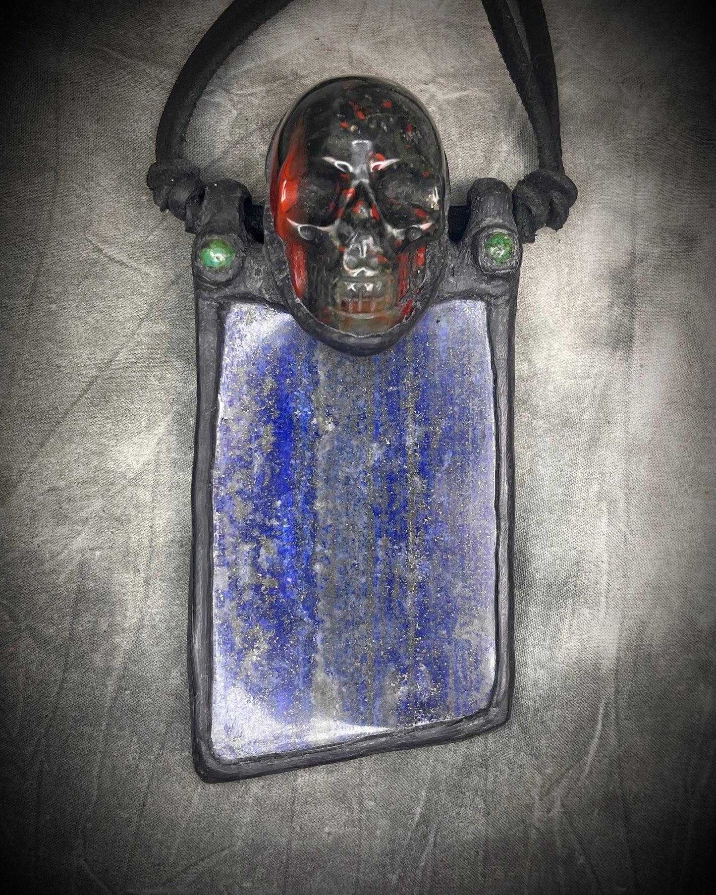 Handmade XL lapis lazuli slab necklace with bloodstone crystal skull, chrysocolla accents, black leather, handmade wire clasp, and bead detail by Anothai Hansen.