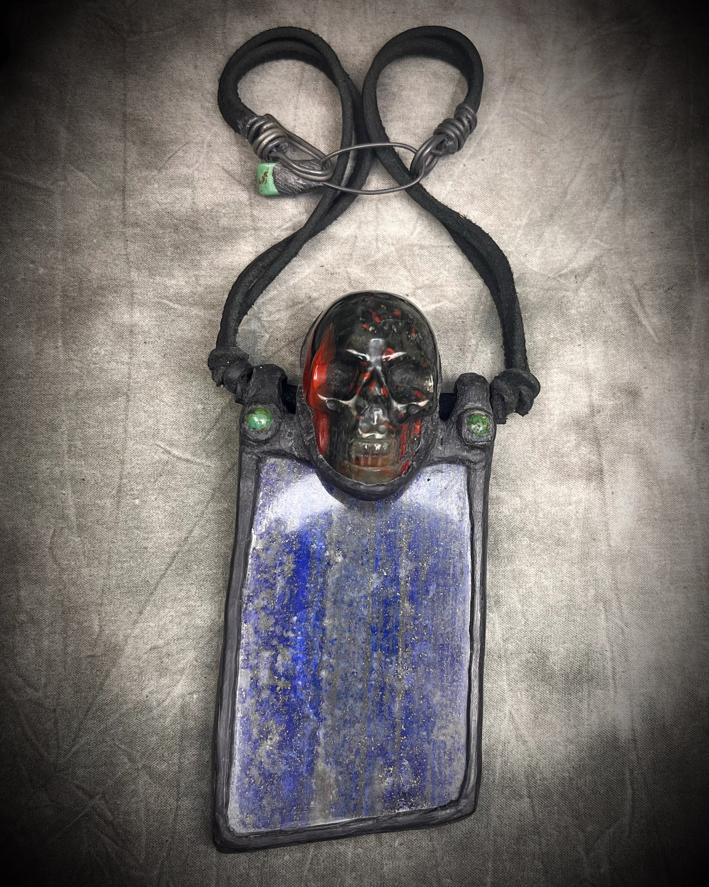 Handmade XL lapis lazuli slab necklace with bloodstone crystal skull, chrysocolla accents, black leather, handmade wire clasp, and bead detail by Anothai Hansen.