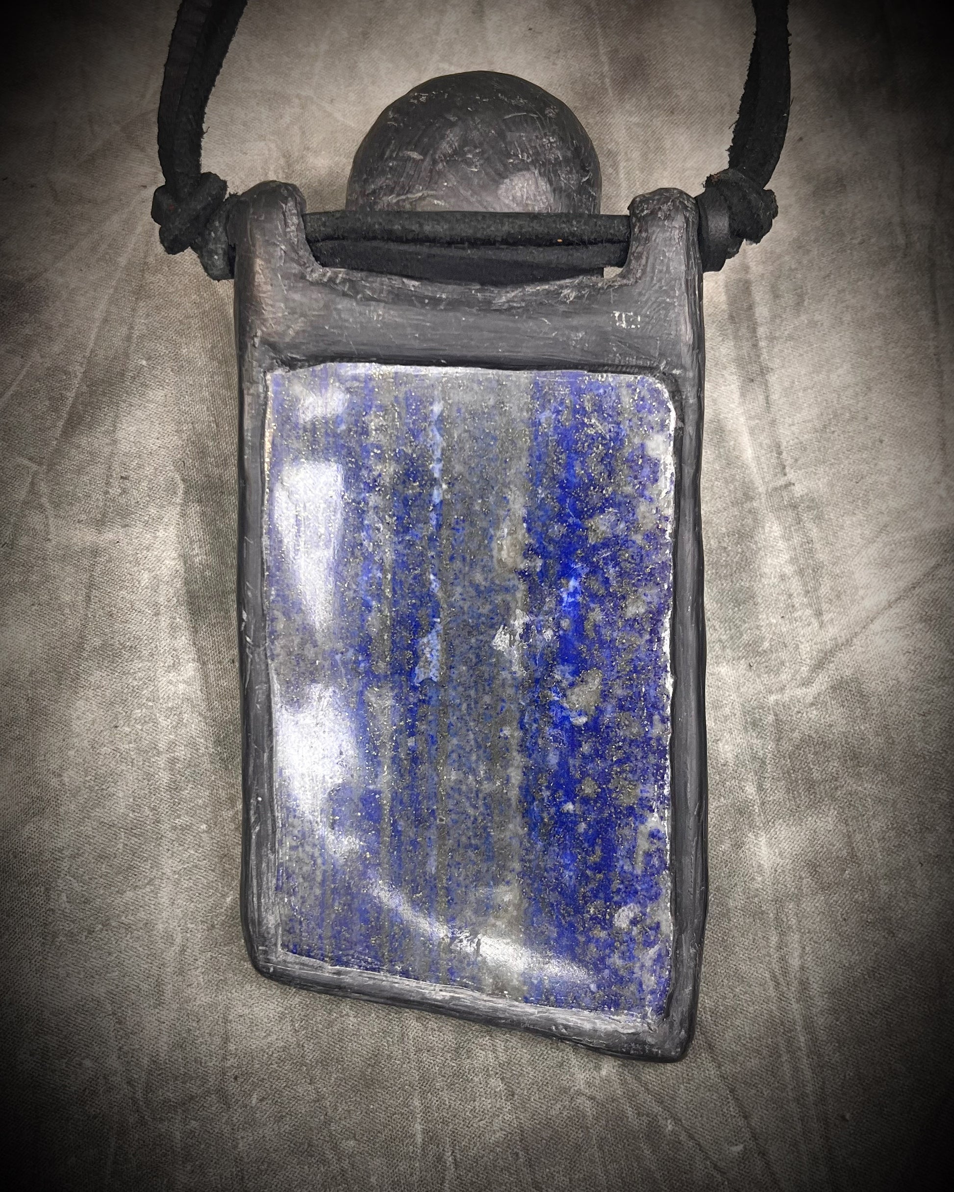 Handmade XL lapis lazuli slab necklace with bloodstone crystal skull, chrysocolla accents, black leather, handmade wire clasp, and bead detail by Anothai Hansen.