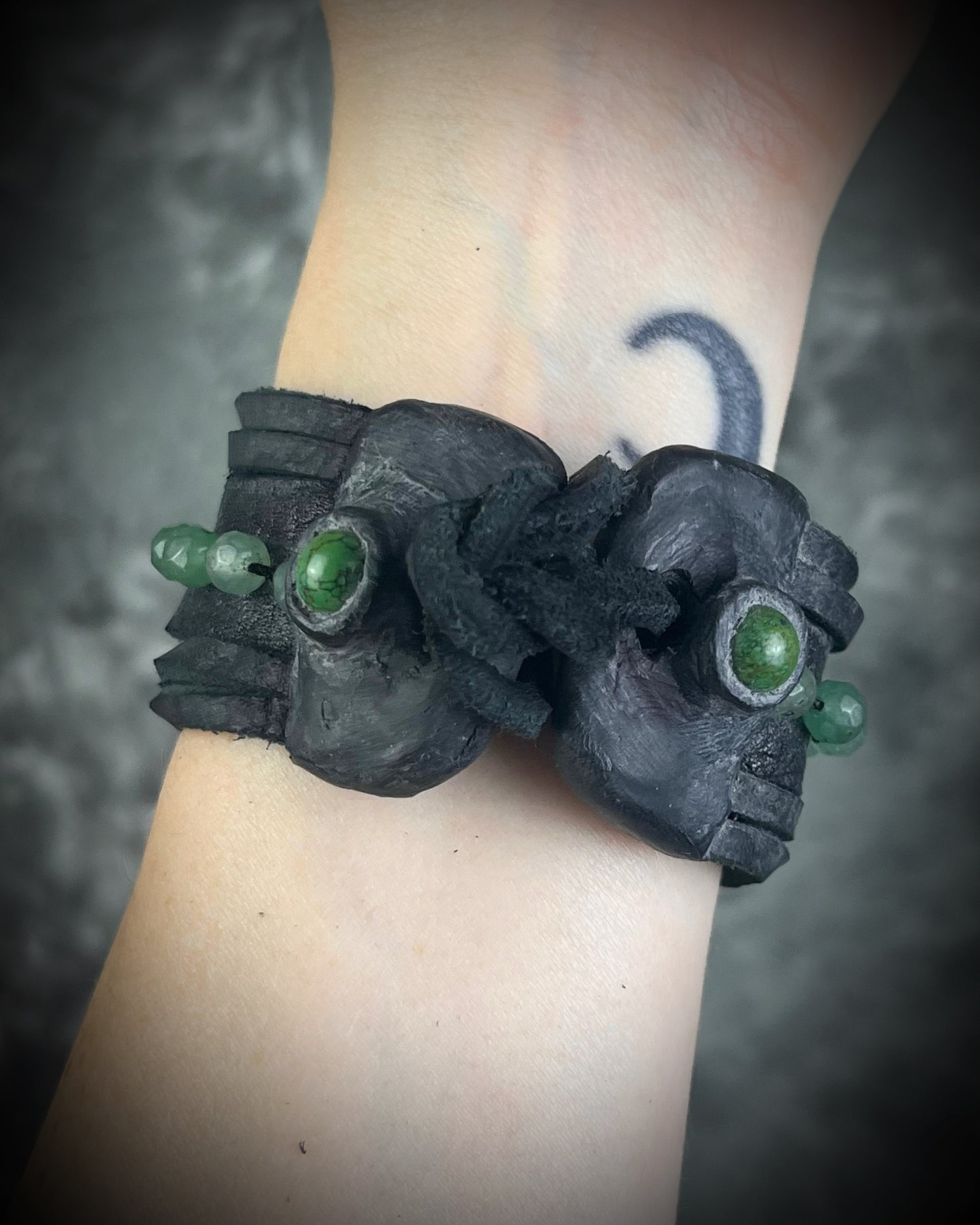 Handmade black leather cuff bracelet with green aventurine beads, chrysocolla accents, layered leather, and adjustable leather tie closure by Anothai Hansen.