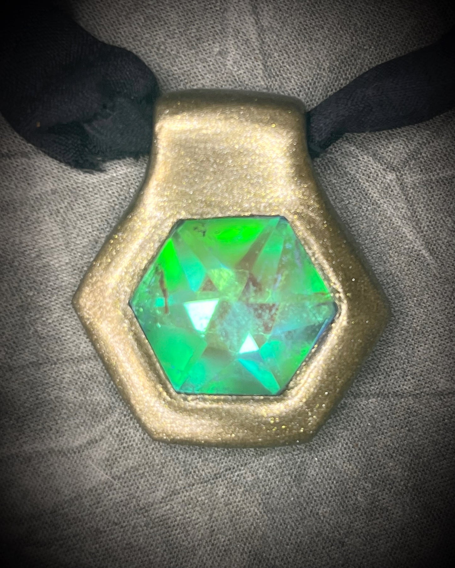 Handmade clear quartz crystal necklace with an aqua flash that feels oceanic and beachy. Framed in gold in a hexagon shape and hung from black recycled silk, this pendant feels like an unearthed treasure. Summer jewelry at its finest!