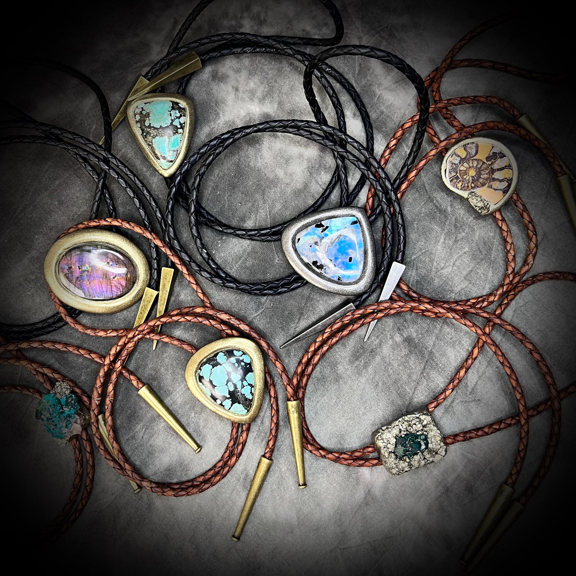 Handmade crystal healing Bolo ties with colorful stone pendants on a textured surface. Mystical western wear bolo ties gift for him or her.