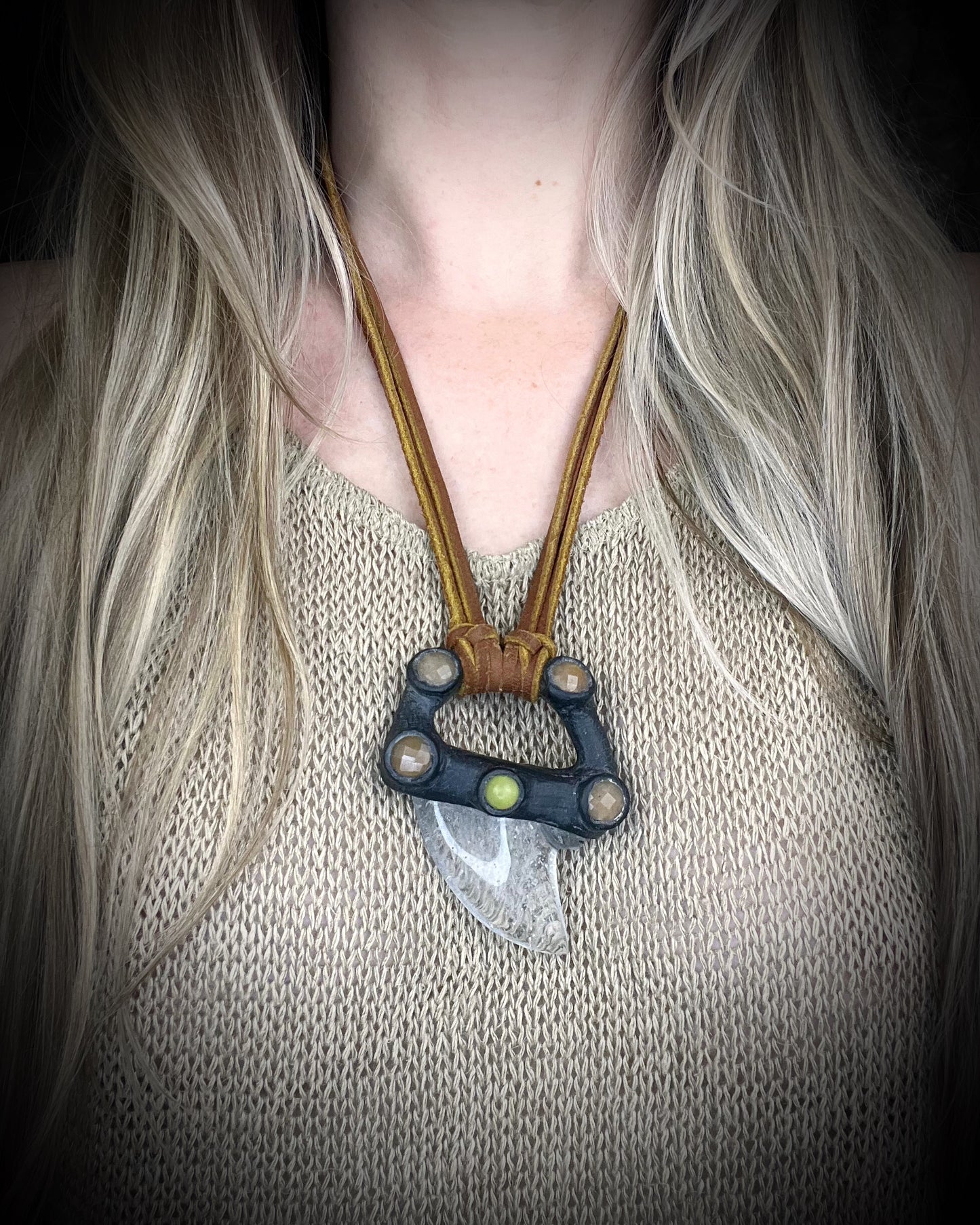 Handmade leather and gemstone pendant by Anothai Hansen featuring a shark tooth shaped quartz crystal accented with warm honey jade and vibrant yellow jade.