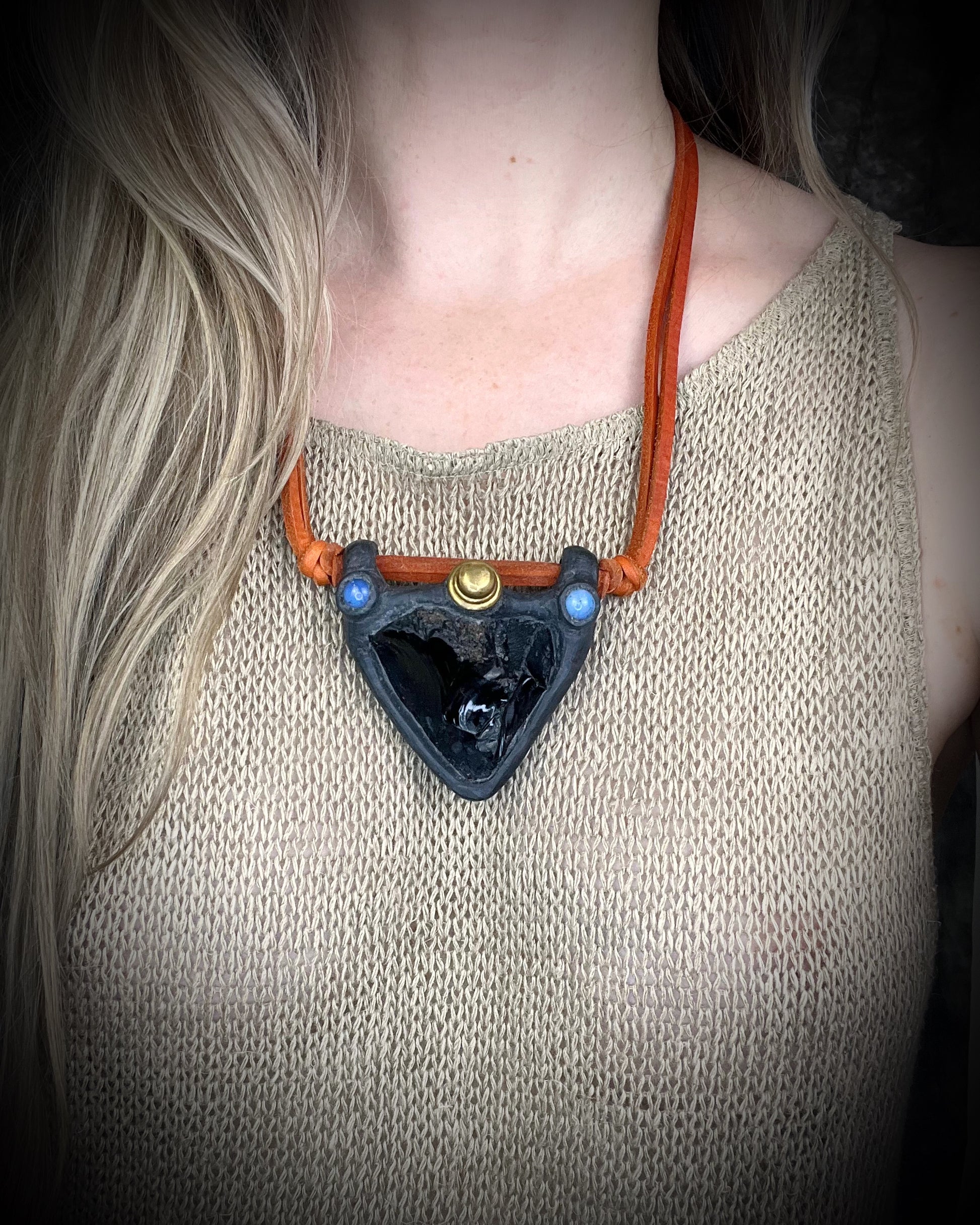 Handmade obsidian pendant with opalite crystals and brass details on orange leather featuring a handmade wire clasp by Anothai Hansen.