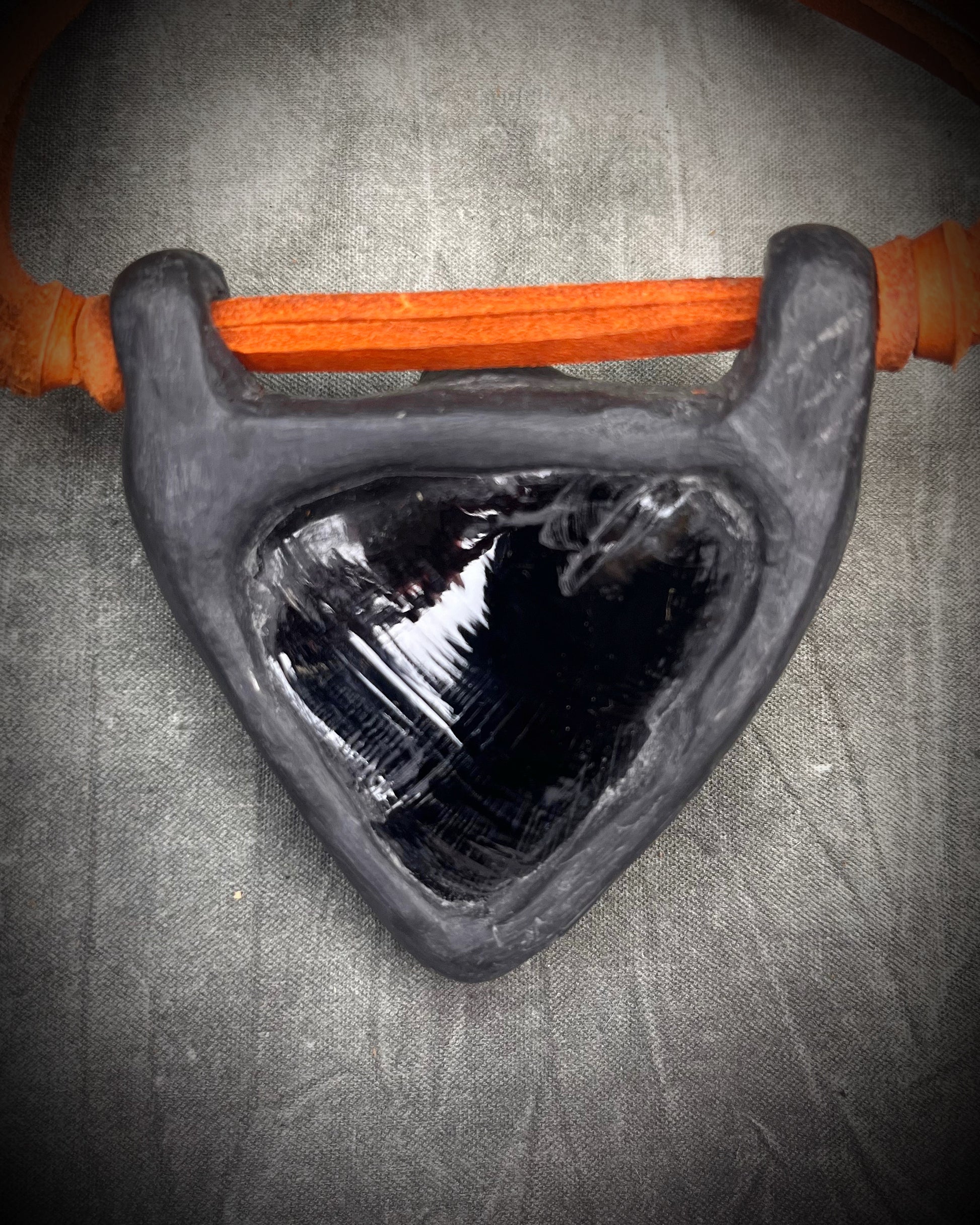 Handmade obsidian pendant with opalite crystals and brass details on orange leather featuring a handmade wire clasp by Anothai Hansen.