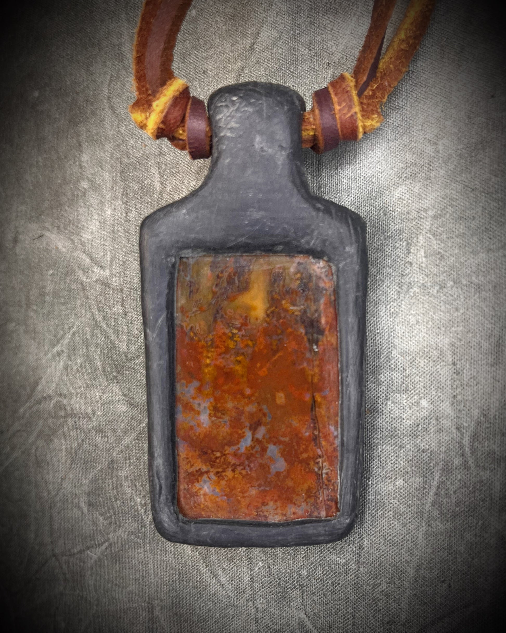 
Handmade red agate pendant with carnelian and abalone shell on brown leather featuring a handmade copper-colored wire clasp by Anothai Hansen.