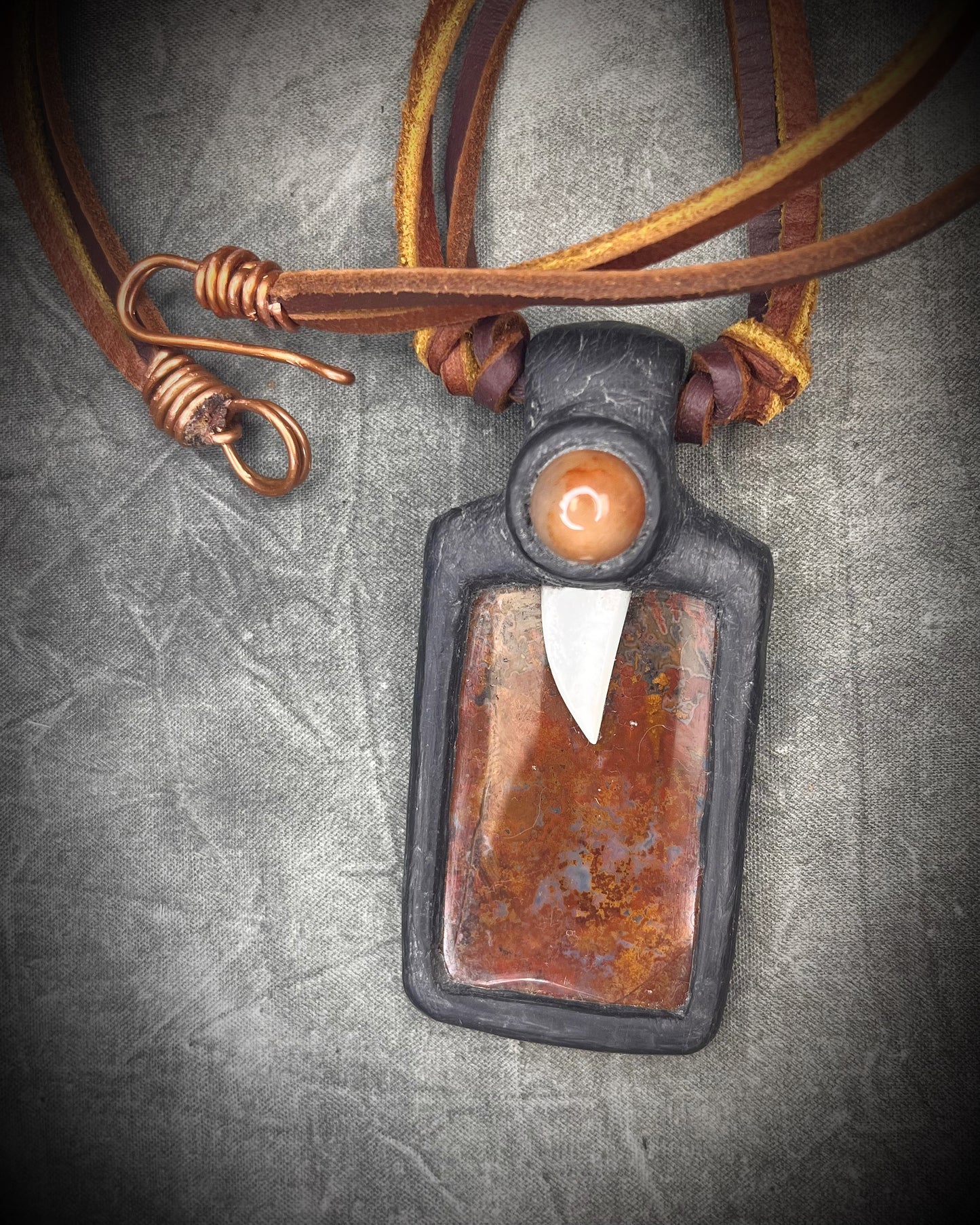 Handmade red agate pendant with carnelian and abalone shell on brown leather featuring a handmade copper-colored wire clasp by Anothai Hansen.