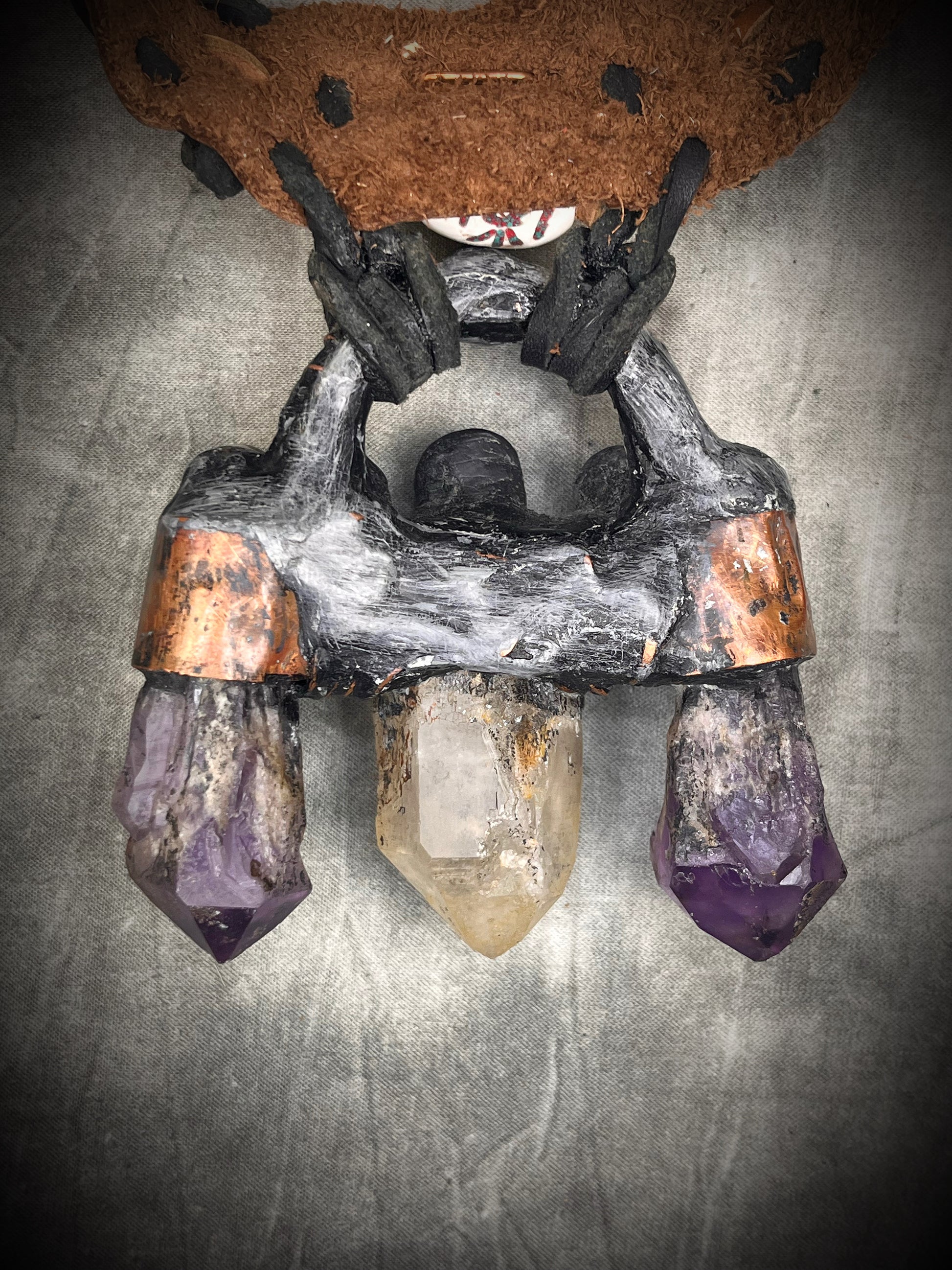Handmade trident leather choker with quartz point, amethyst points, yellow jade, brass details, and copper wire clasp by Anothai Hansen.