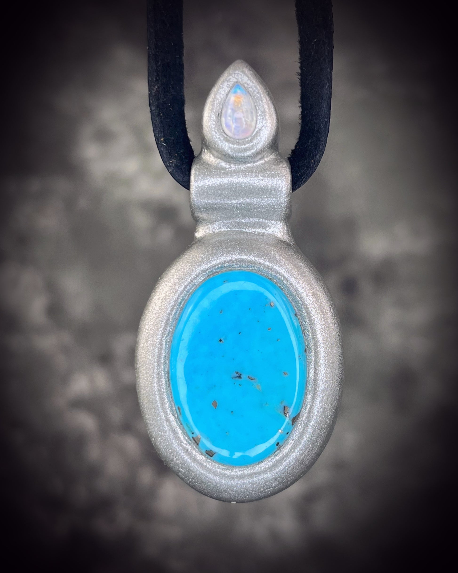 Handmade turquoise and moonstone crystal necklace suspended from leather, featuring natural turquoise and luminous moonstone, artisan jewelry by Become Spellbound.