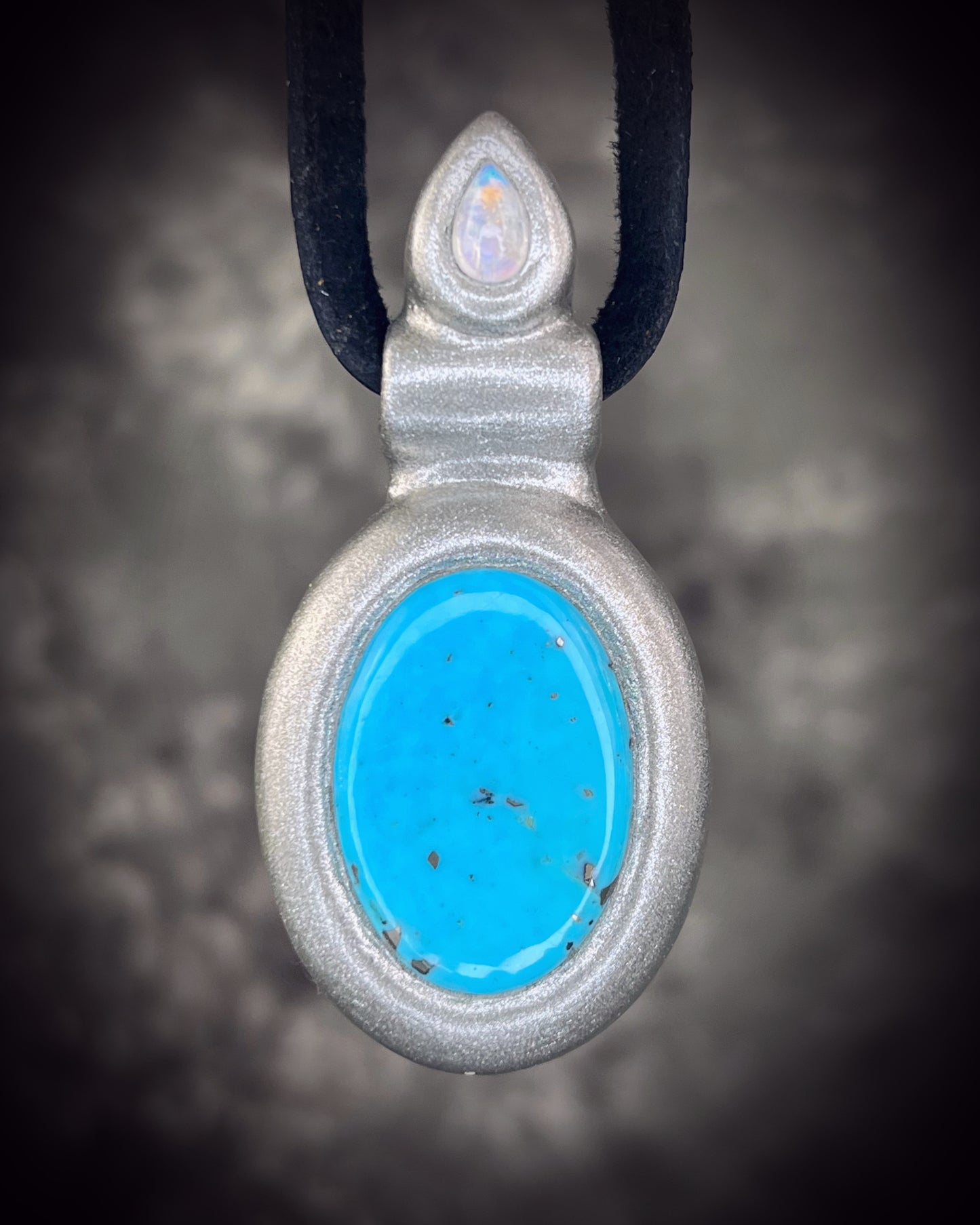 Handmade turquoise and moonstone crystal necklace suspended from leather, featuring natural turquoise and luminous moonstone, artisan jewelry by Become Spellbound.