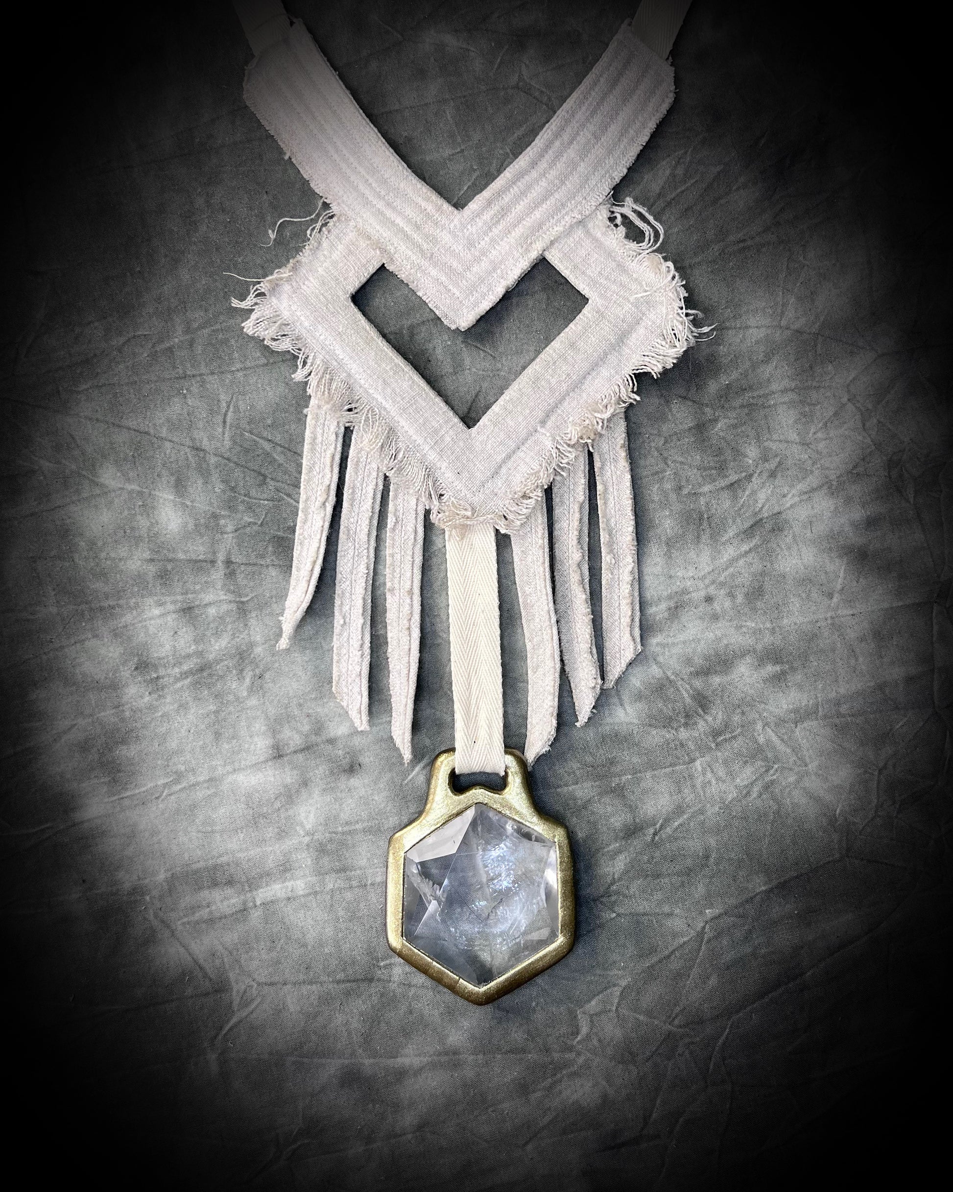 A stunning handmade raw linen collar statement style necklace featuring a handcrafted quartz star of david hexagon crystal and geometric shapes and fringe.  Wearable art for a boho free spirit or festival jewelry!