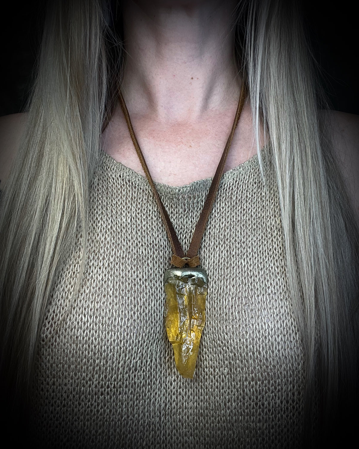 Honey calcite crystal talisman with warm golden tones in a sculptural setting on brown leather, handmade by Become Spellbound in Baltimore, Maryland.
