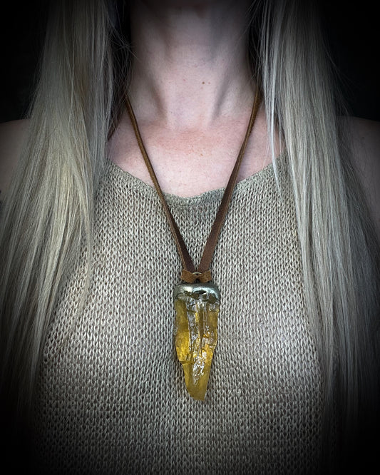 Honey calcite crystal talisman with warm golden tones in a sculptural setting on brown leather, handmade by Become Spellbound in Baltimore, Maryland.