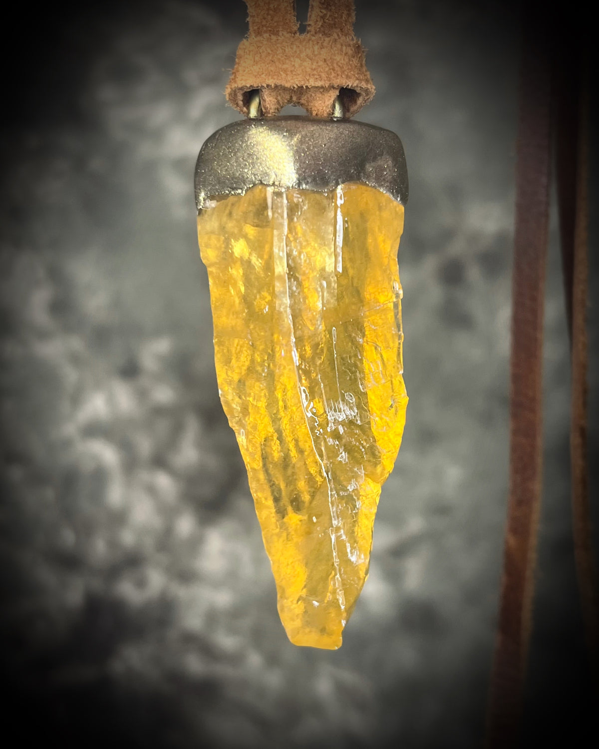 Honey calcite crystal talisman with warm golden tones in a sculptural setting on brown leather, handmade by Become Spellbound in Baltimore, Maryland.