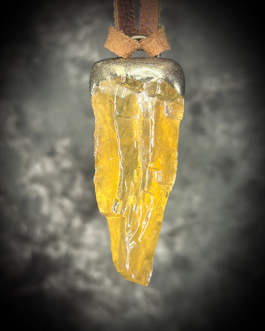 Honey calcite crystal talisman with warm golden tones in a sculptural setting on brown leather, handmade by Become Spellbound in Baltimore, Maryland.