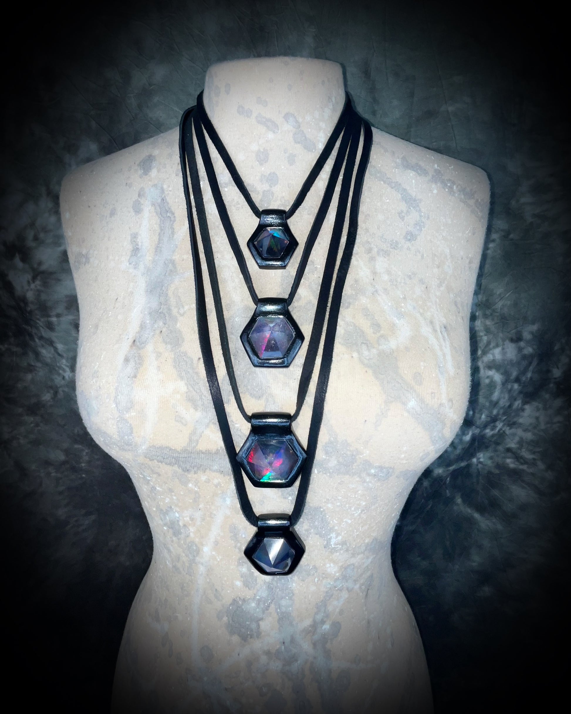 Four stacked black David Bowie inspired designer quartz rainbow necklaces. On matching black leather customizable from choker to long.  Queer, Transgender, Non-Binary jewelry.