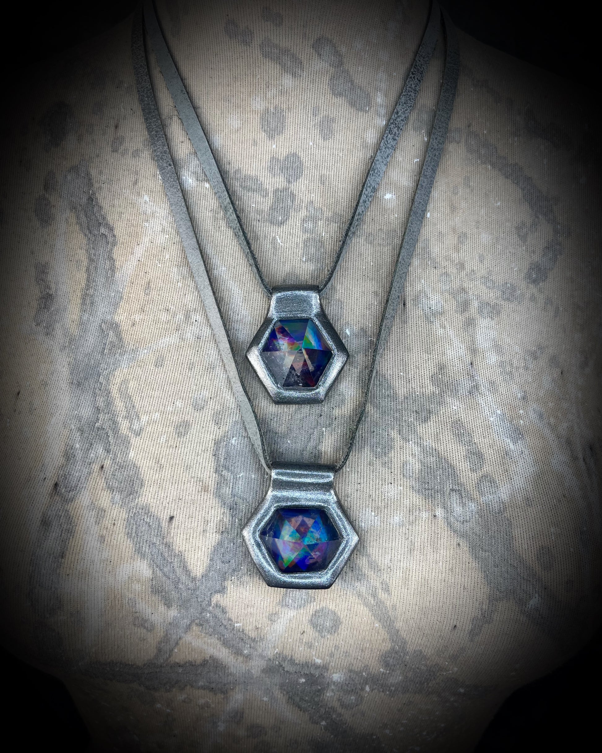 Closeup stacked gunmetal silver David Bowie inspired designer quartz rainbow necklaces, matching silver leather customizable from choker to pendant. 