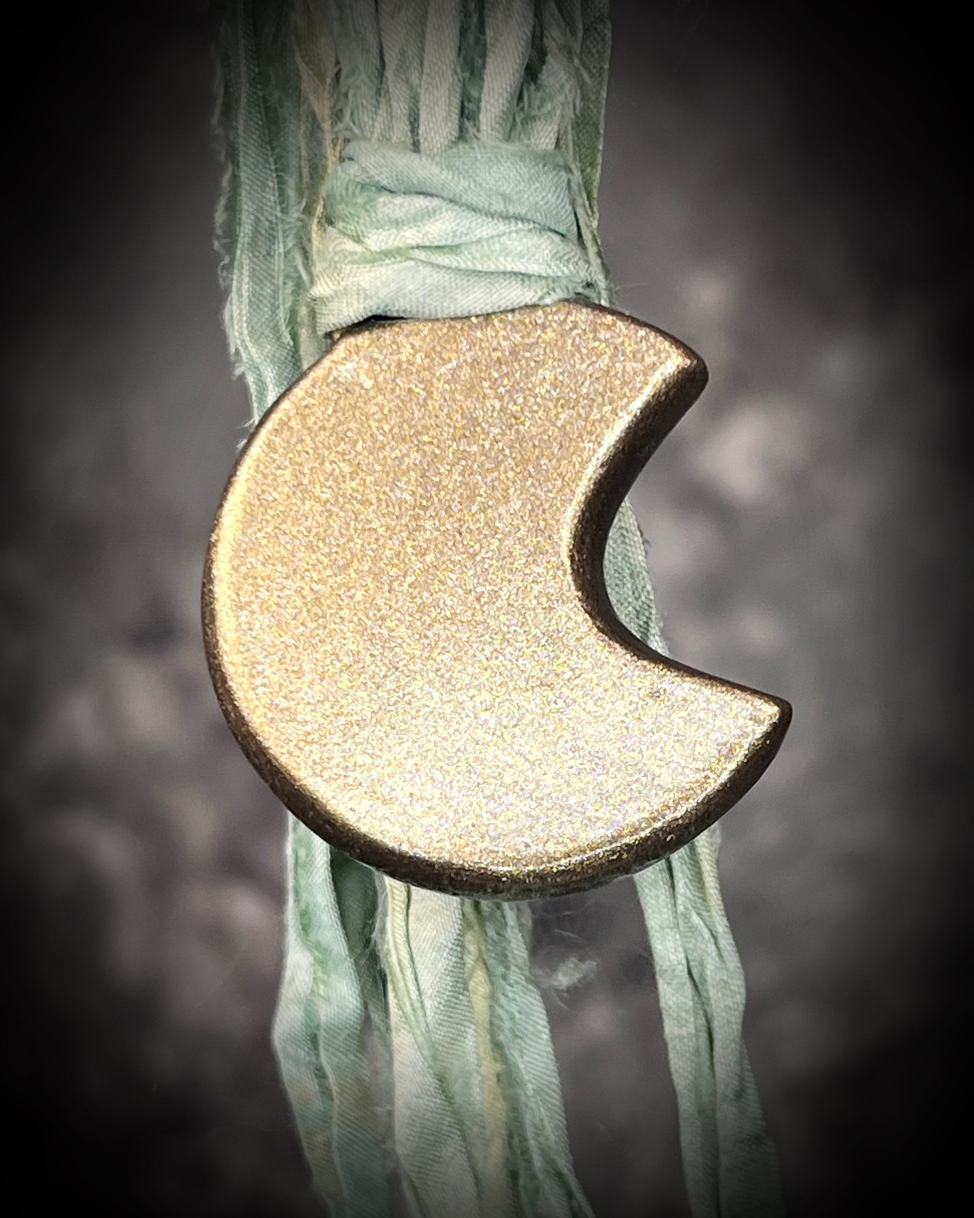 Labradorite moon talisman with high natural flash, sculpted gold finish, and aqua green recycled silk ties by Become Spellbound.