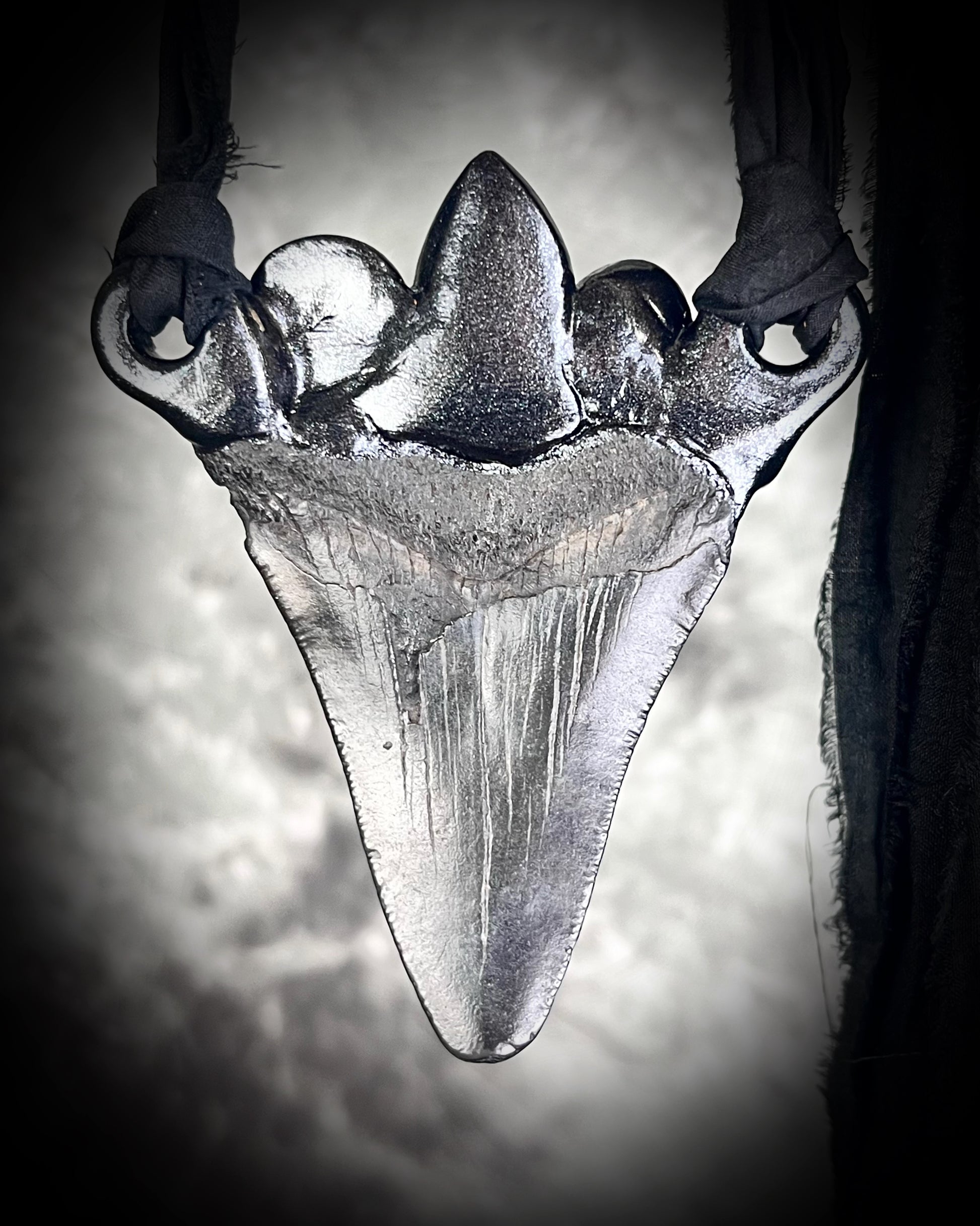 Large megalodon tooth necklace crowned with citrine, opal, black opal, labradorite, dioptase, golden tourmaline, lapis lazuli, and moonstone — set in black and hung from recycled silk ribbons.