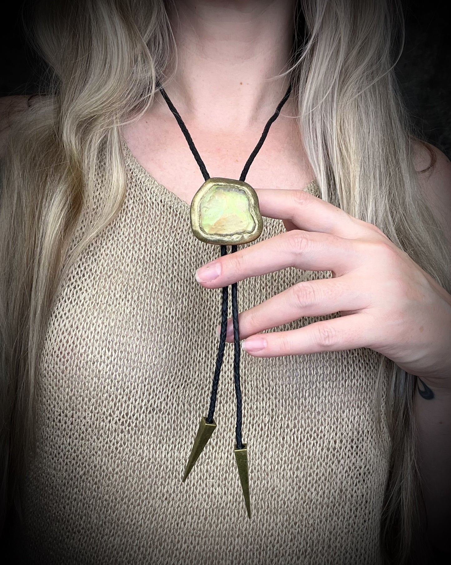 Libyan Desert Glass bolo tie with sculpted gold finish, black leather cord, and gold spike bolo tips by Become Spellbound, Baltimore Magazine Best of Baltimore 2026 Jewelry winner.