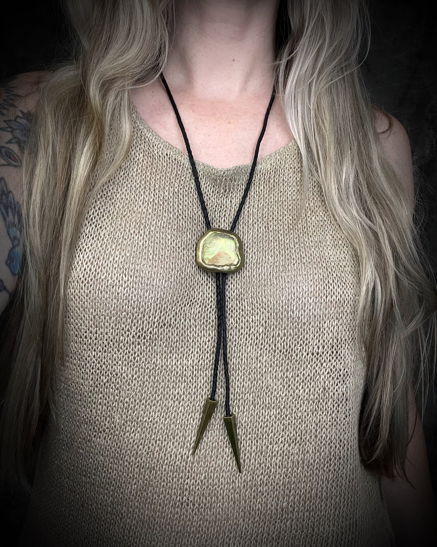Libyan Desert Glass bolo tie with sculpted gold finish, black leather cord, and gold spike bolo tips by Become Spellbound, Baltimore Magazine Best of Baltimore 2026 Jewelry winner.