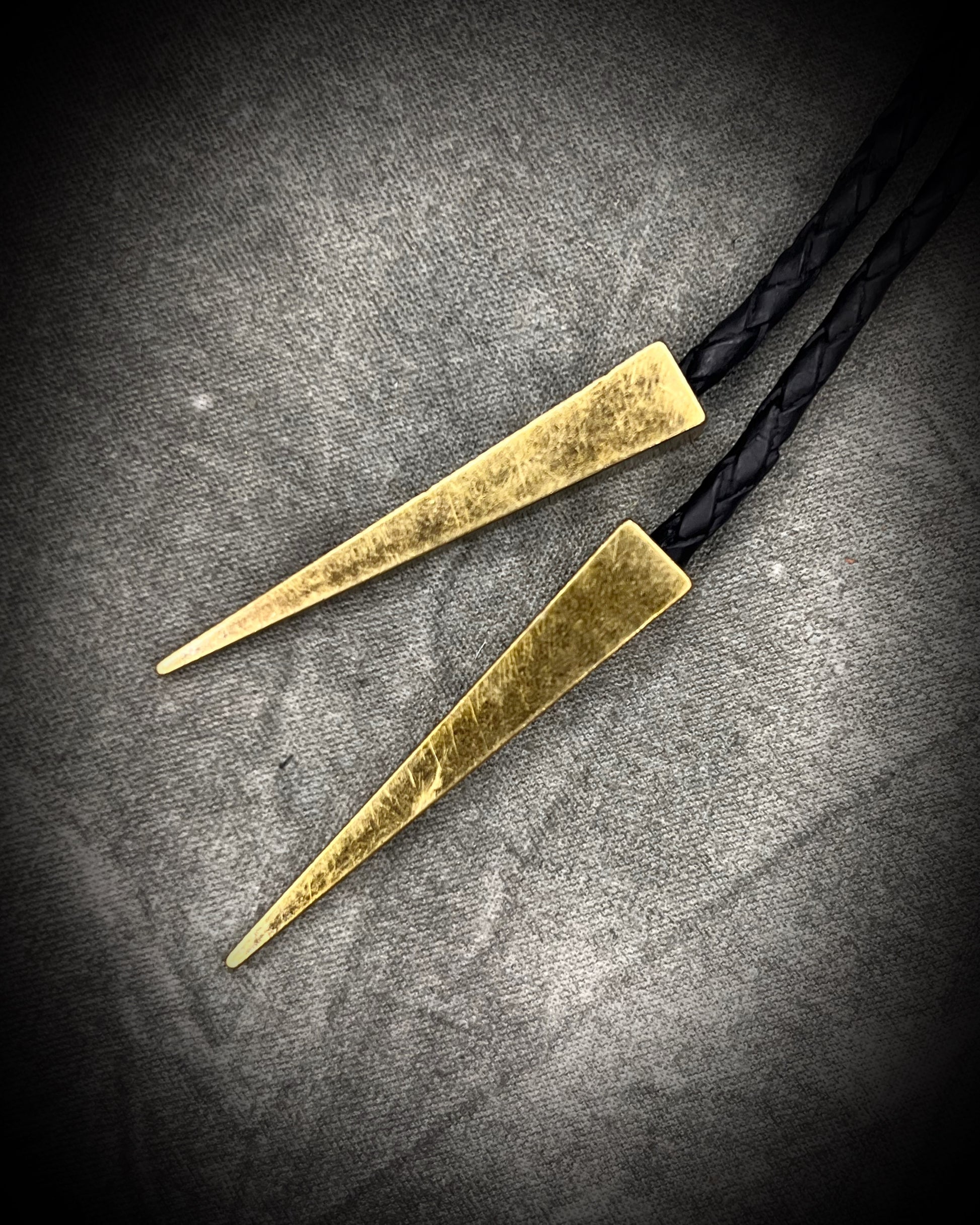 Libyan Desert Glass bolo tie with sculpted gold finish, black leather cord, and gold spike bolo tips by Become Spellbound, Baltimore Magazine Best of Baltimore 2026 Jewelry winner.